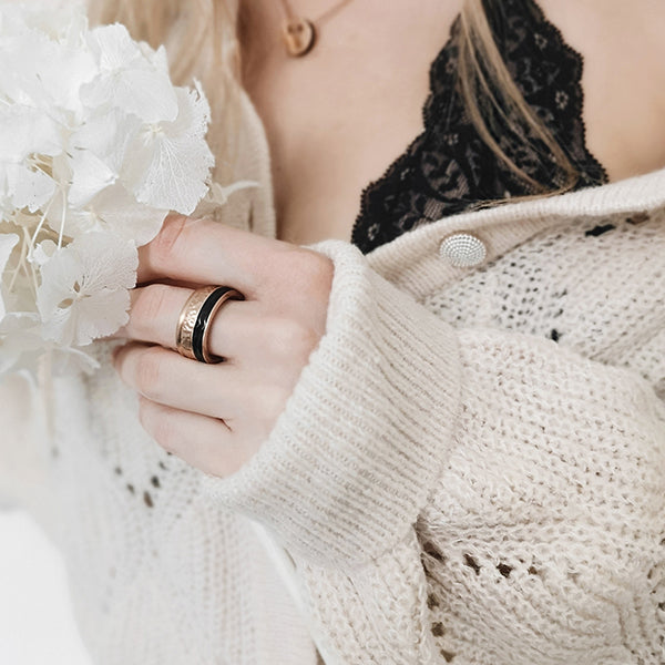 Gesamtansicht eines Damenrings aus schwarz geschliffenen Edelstahl mit einer roséfarbenen Fassung von MONOMANIA.