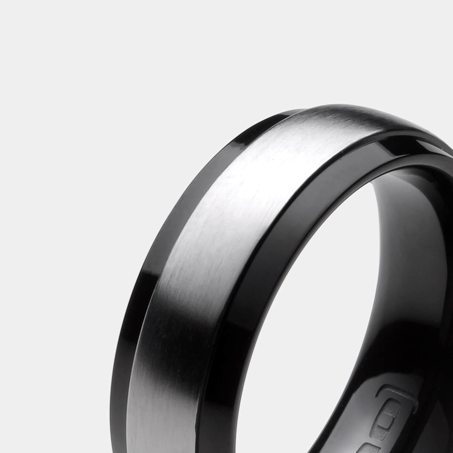 Gesamtansicht eines schwarzen Edelstahl-Rings mit matter, silberfarbener Mittelfläche von MONOMANIA.