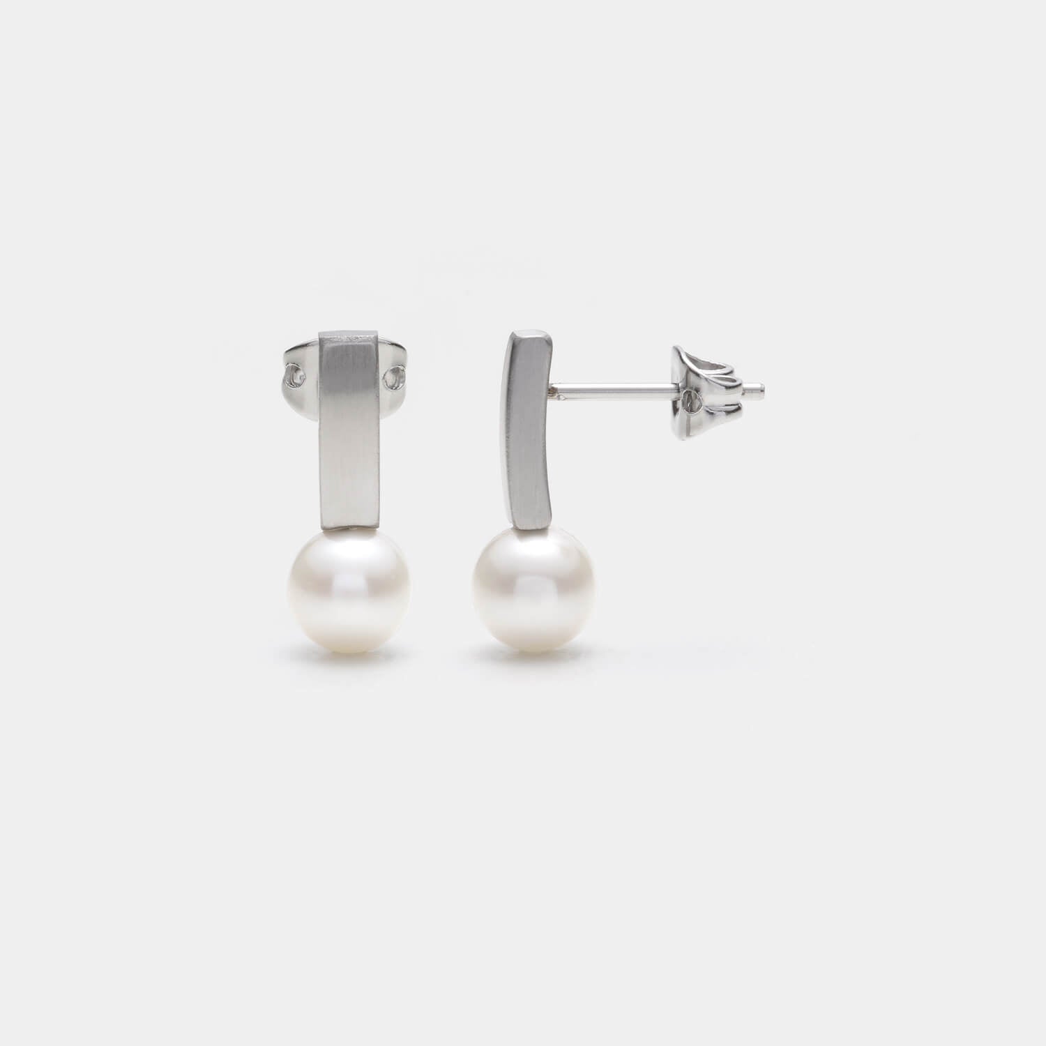 Perspektivische Ansicht der Pearl´s Kiss Ohrstecker aus gebürstetem, antiallergenen Edelstahl und einer gesetzten weißen Süßwasserperle von MONOMANIA.
