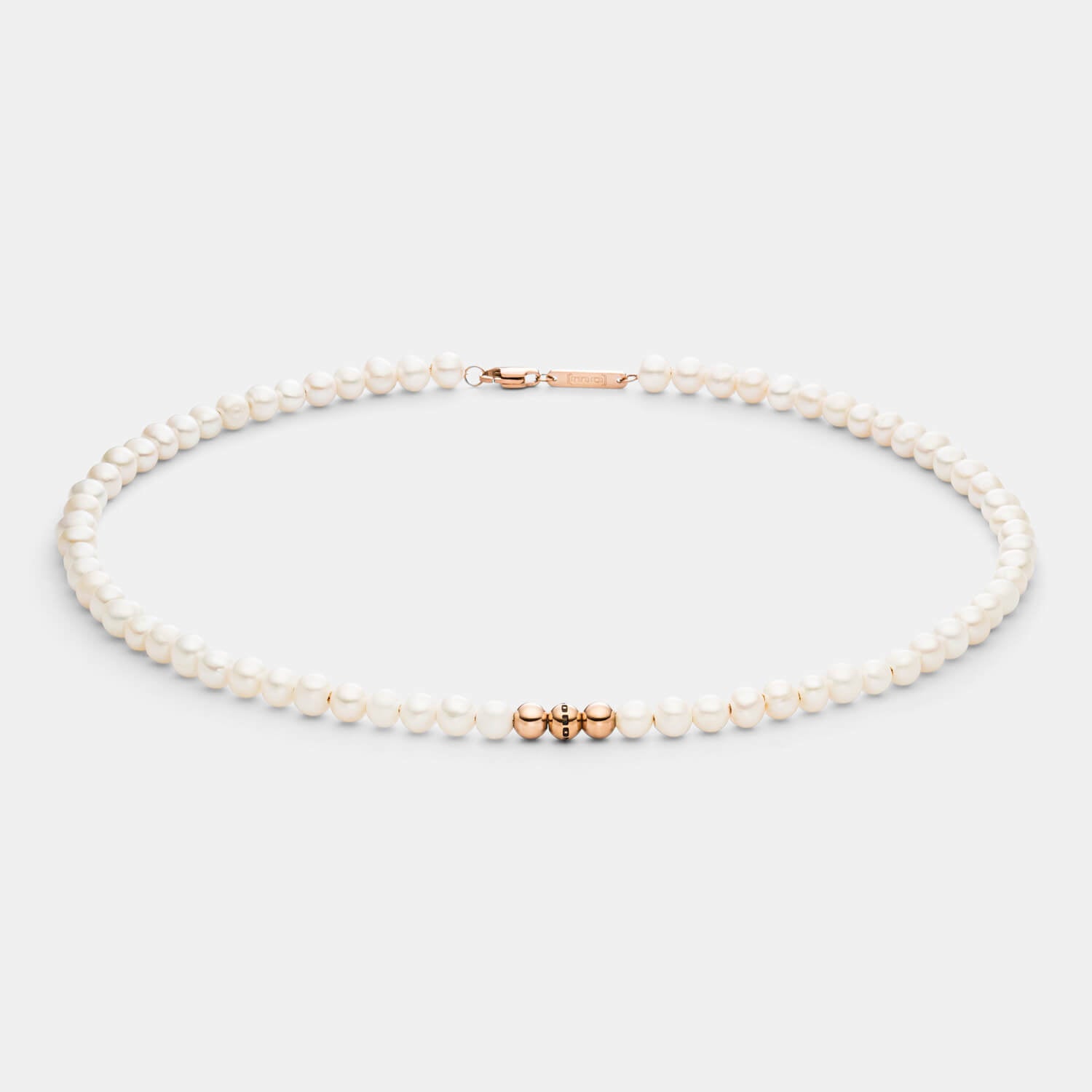 Detailansicht einer Perlenkette aus weißen Süßwasserperlen mit drei antiallergenen Edelstahlperlen.