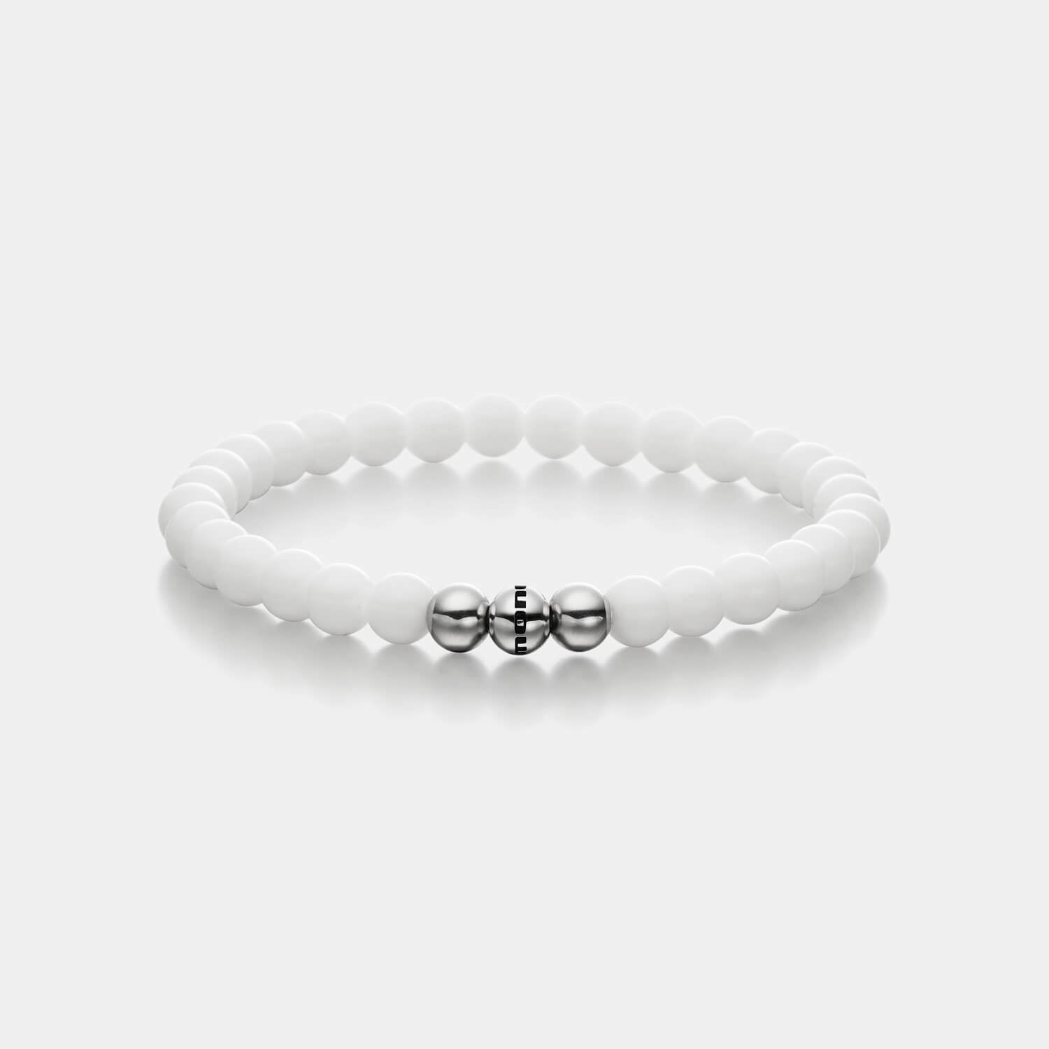 Gesamtansicht eines weißen Perlenarmbandes aus echten Bergkristallperlen mit drei antiallergenen Edelstahlperlen.