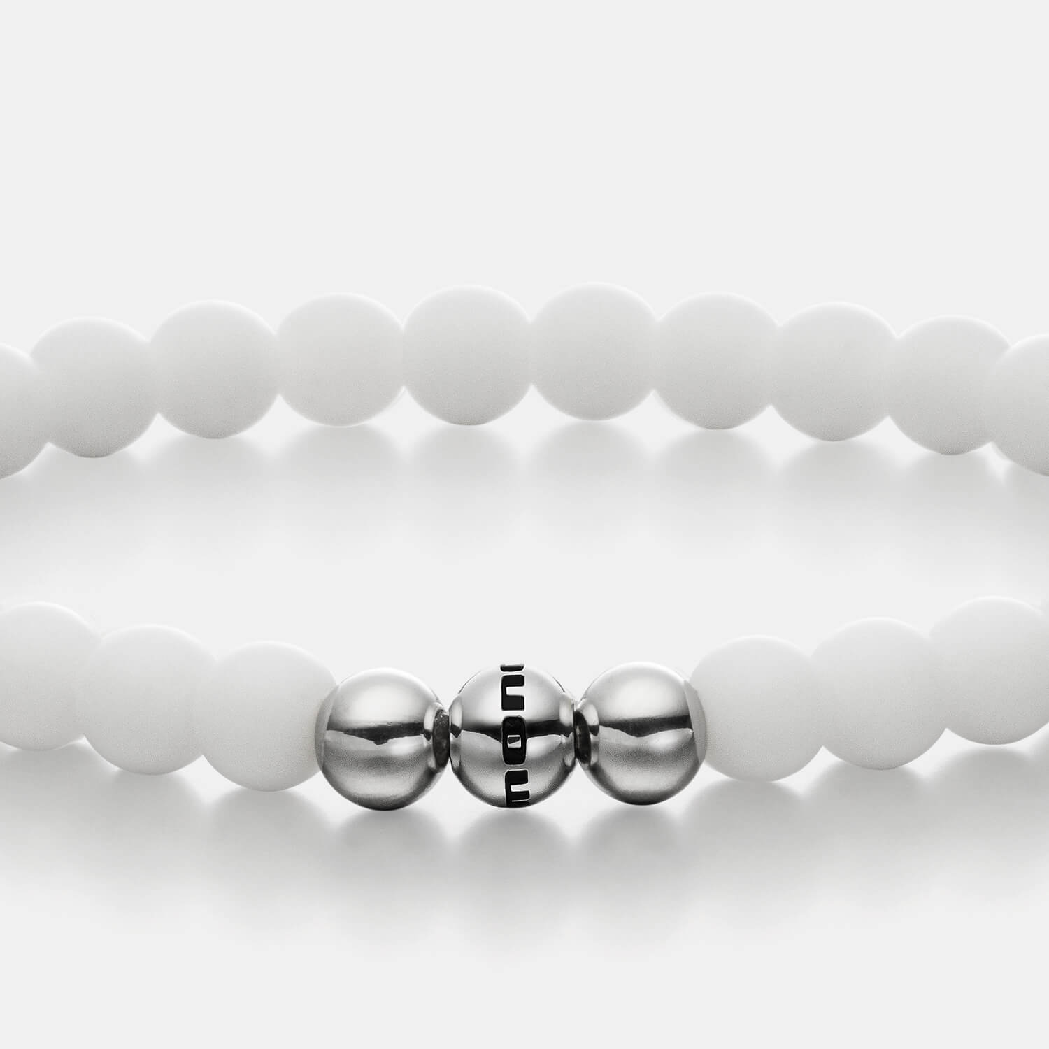 Gesamtansicht eines weißen Perlenarmbandes aus echten Achatperlen mit drei antiallergenen Edelstahlperlen.