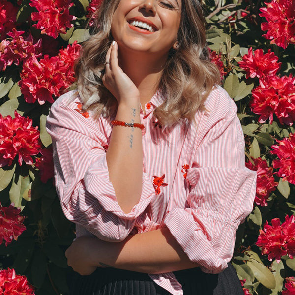 Gesamtansicht eines roten Perlenarmbandes aus echten Carneol-Perlen mit drei antiallergenen Edelstahlperlen.