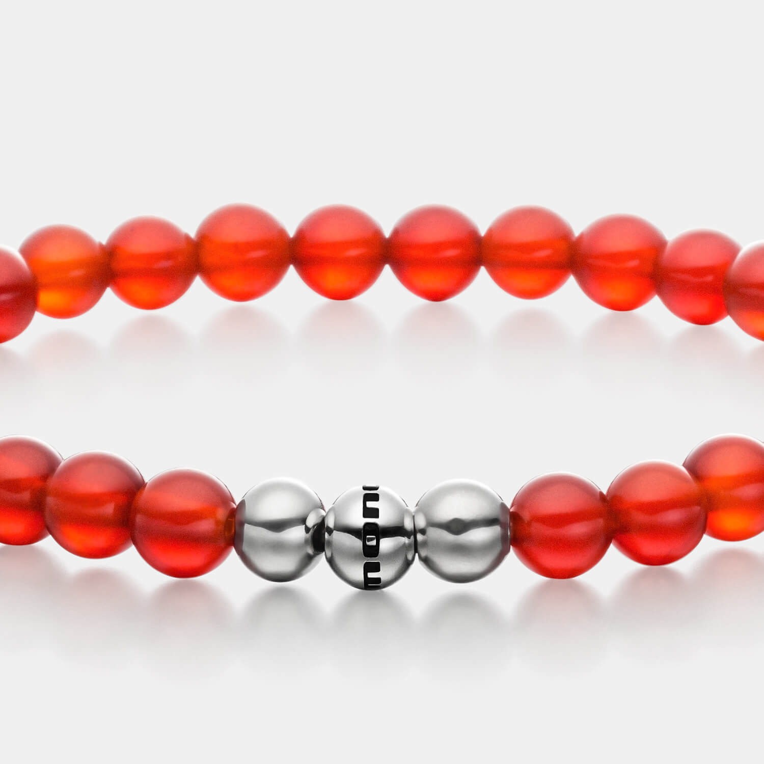 Gesamtansicht eines roten Perlenarmbandes aus echten Carneol-Perlen mit drei antiallergenen Edelstahlperlen.