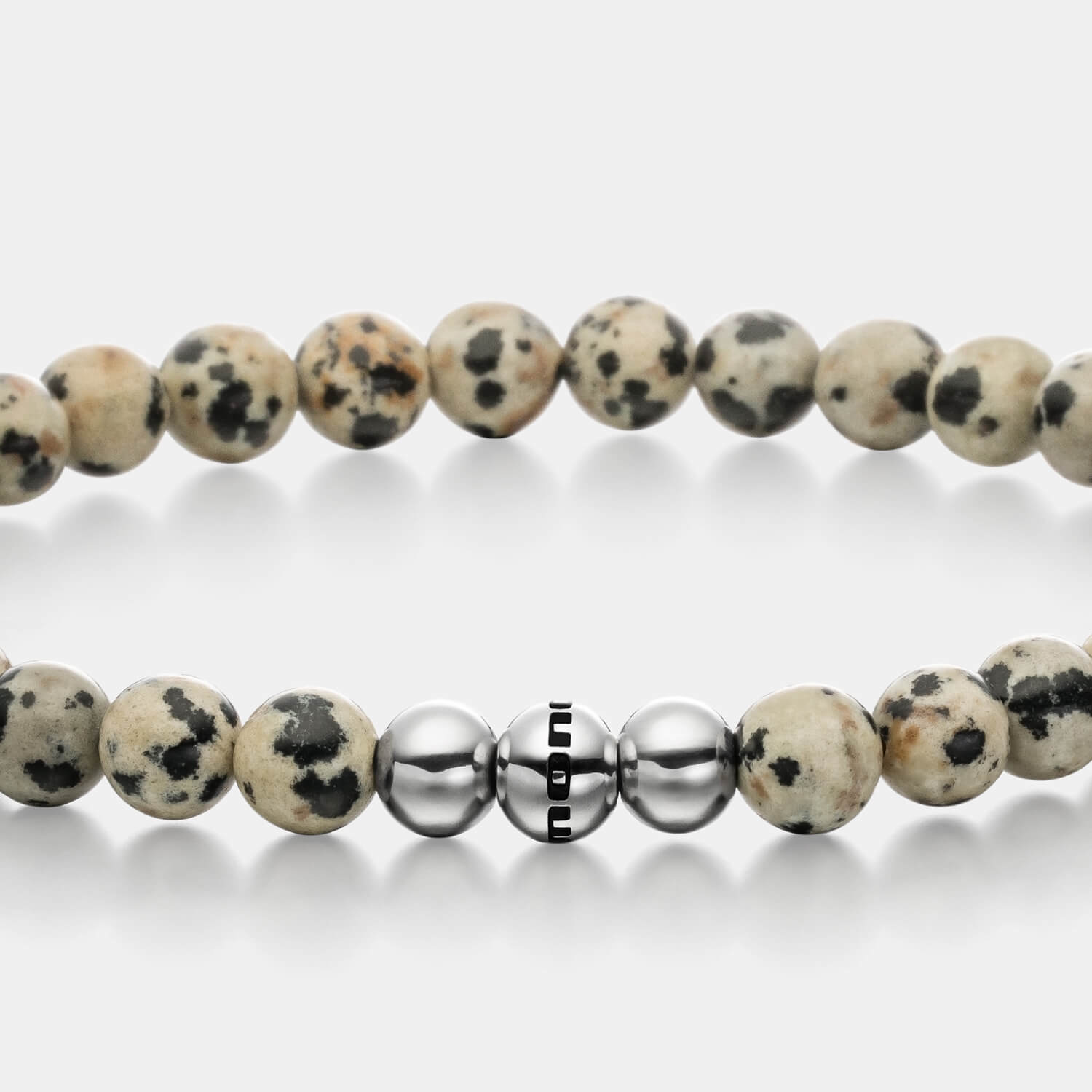 Gesamtansicht eines aufregenden Perlenarmbandes aus echten Dalmatiner-Jaspisperlen mit drei antiallergenen Edelstahlperlen.