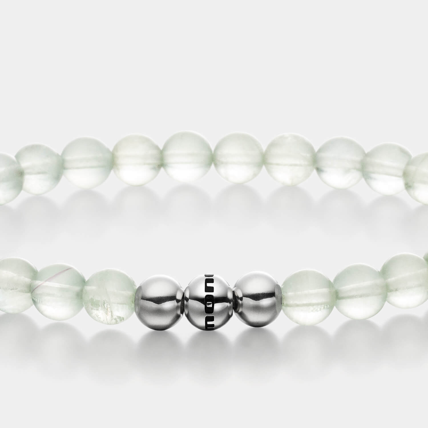Gesamtansicht eines hellgrünen Perlenarmbandes aus echten Fluoritperlen mit drei antiallergenen Edelstahlperlen.