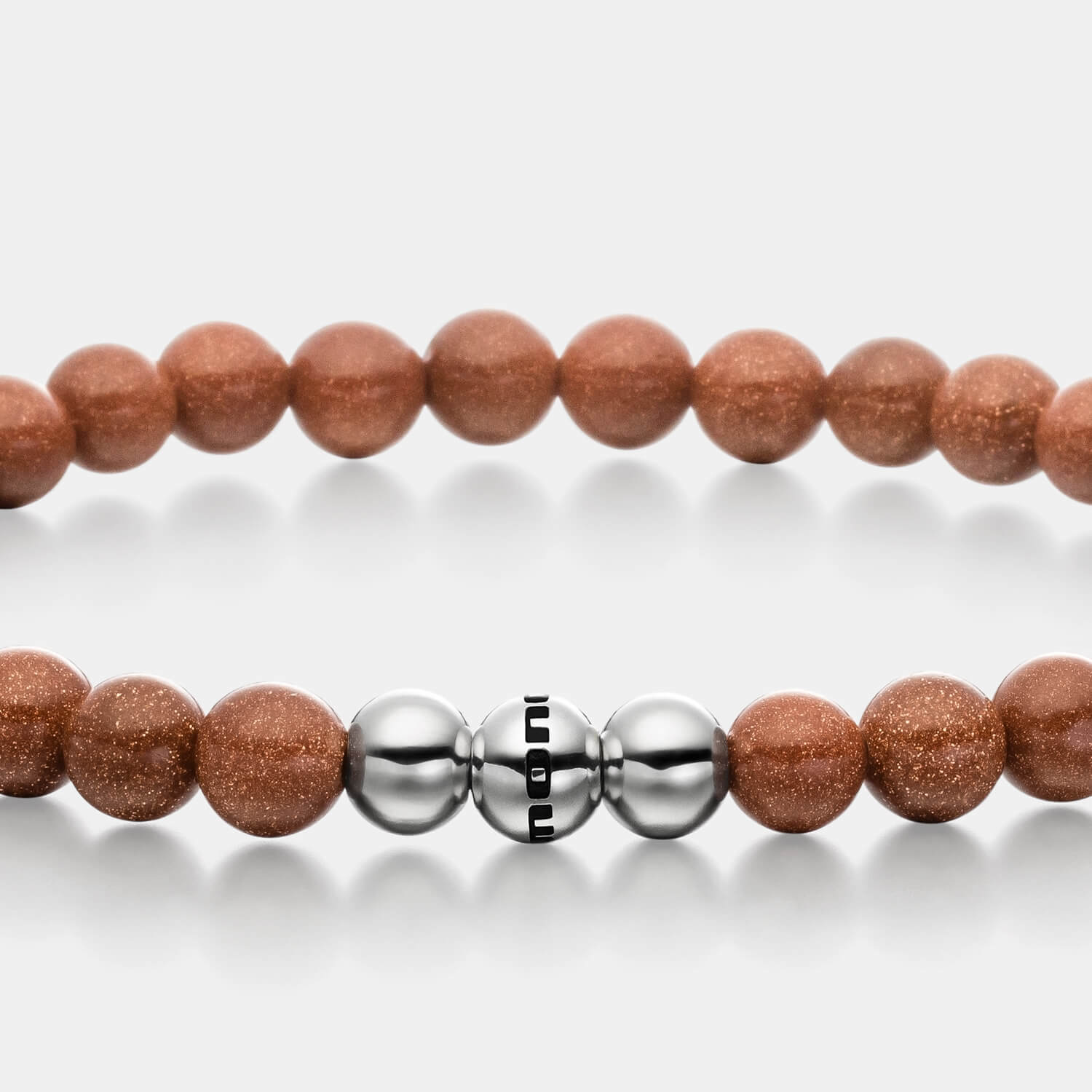 Gesamtansicht eines braunen Perlenarmbandes aus echten Goldflussperlen mit drei antiallergenen Edelstahlperlen.