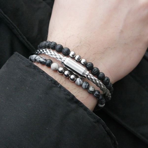 Gesamtansicht eines schwarzen Perlenarmbandes aus echten Lavaperlen mit drei antiallergenen Edelstahlperlen.