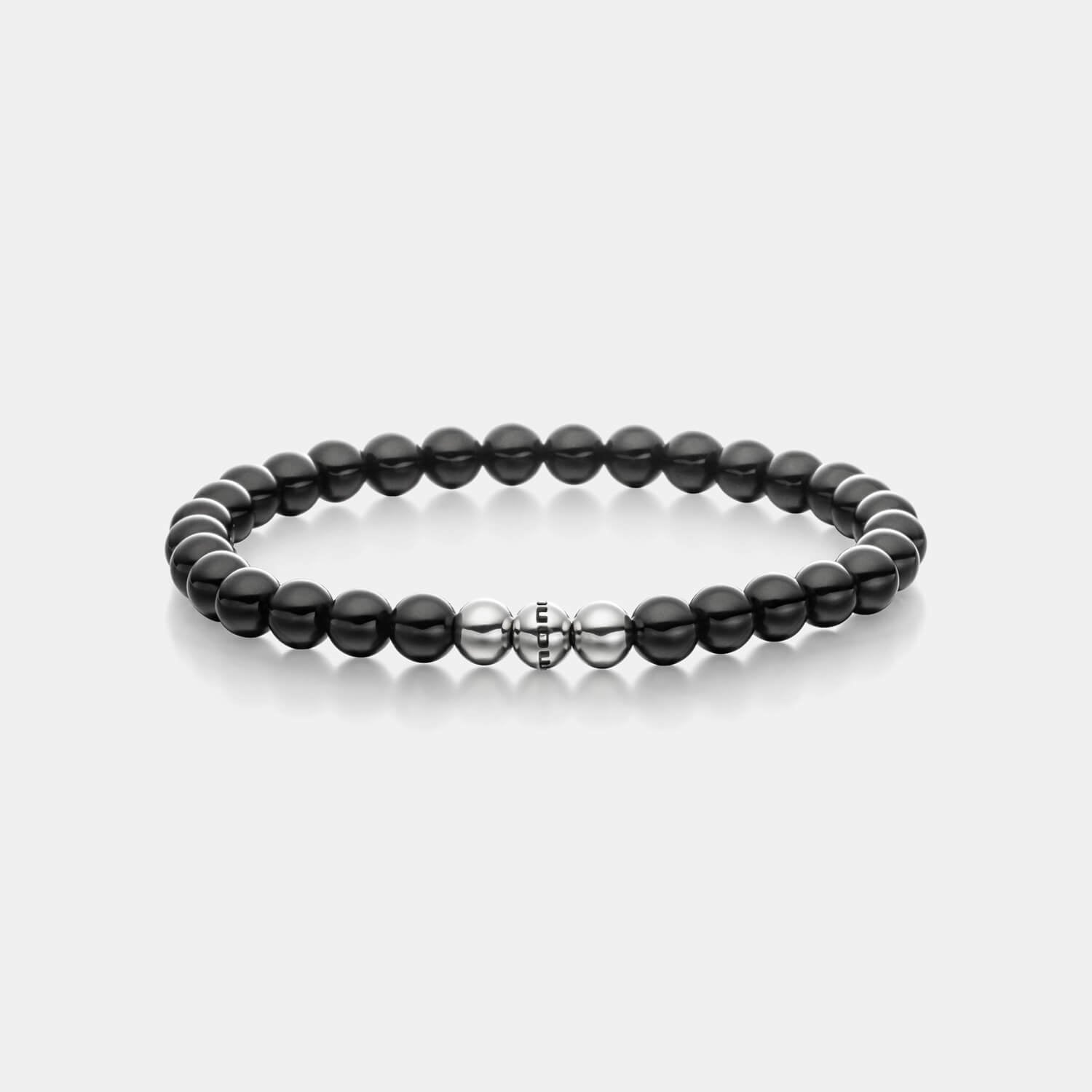 Gesamtansicht eines schwarzen Perlenarmbandes aus echten Onyxperlen mit drei antiallergenen Edelstahlperlen.