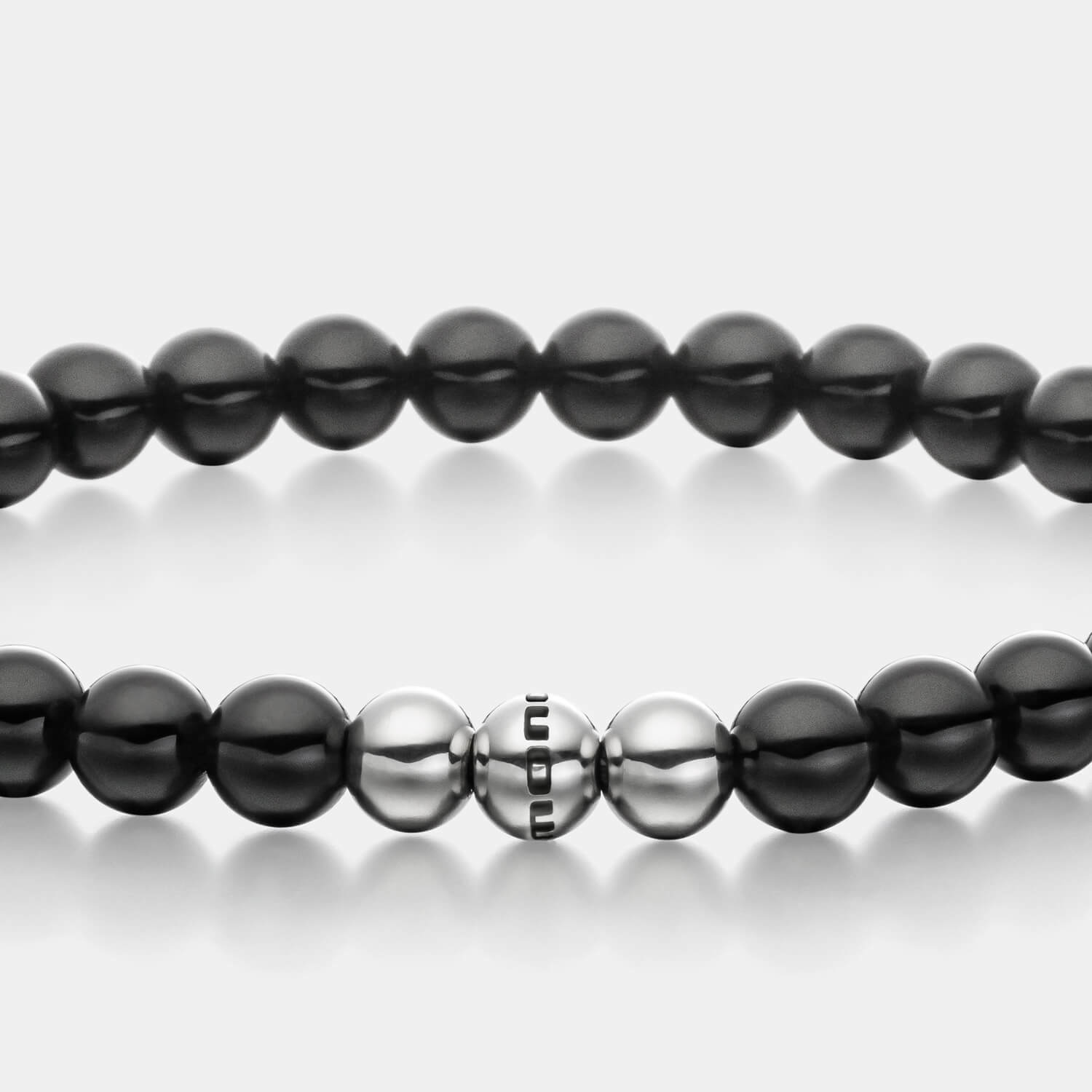 Gesamtansicht eines schwarzen Perlenarmbandes aus echten Onyxperlen mit drei antiallergenen Edelstahlperlen.