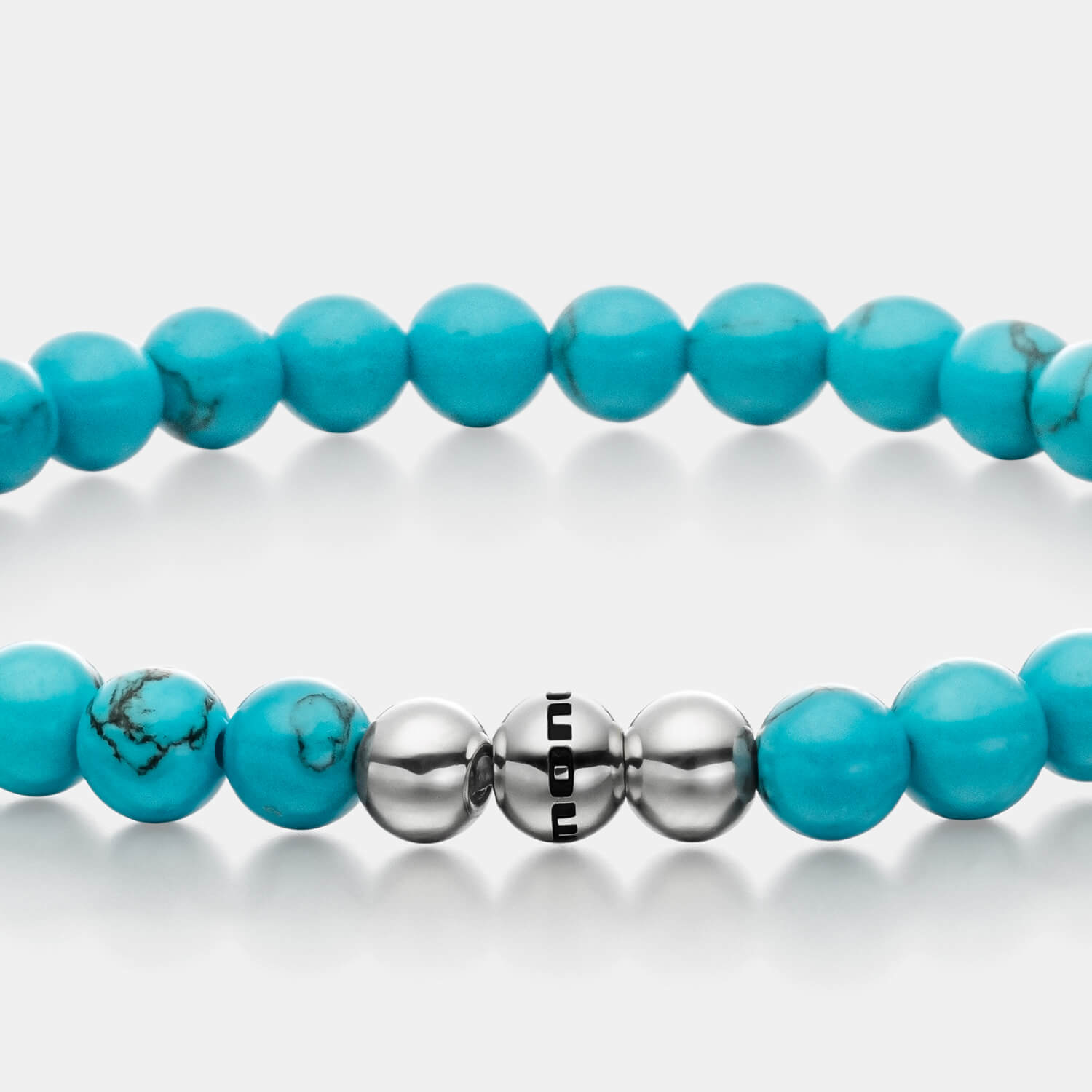 Gesamtansicht eines Perlenarmbandes aus echten Türkis-Perlen mit drei antiallergenen Edelstahlperlen.