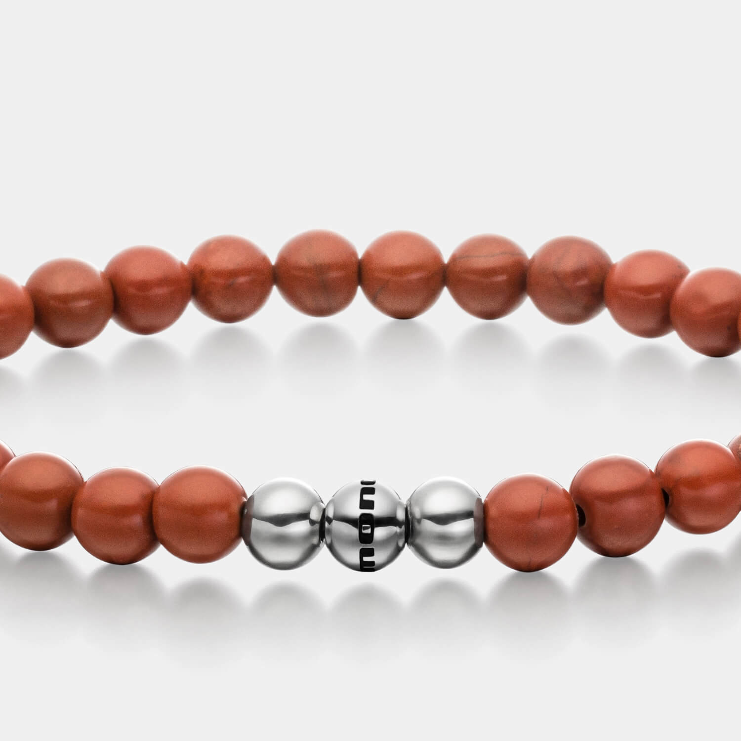 Gesamtansicht eines roten Perlenarmbandes aus echten Jaspisperlen mit drei antiallergenen Edelstahlperlen.