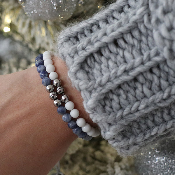 Gesamtansicht eines blauen Perlenarmbandes aus echten Sodalithperlen mit drei antiallergenen Edelstahlperlen.