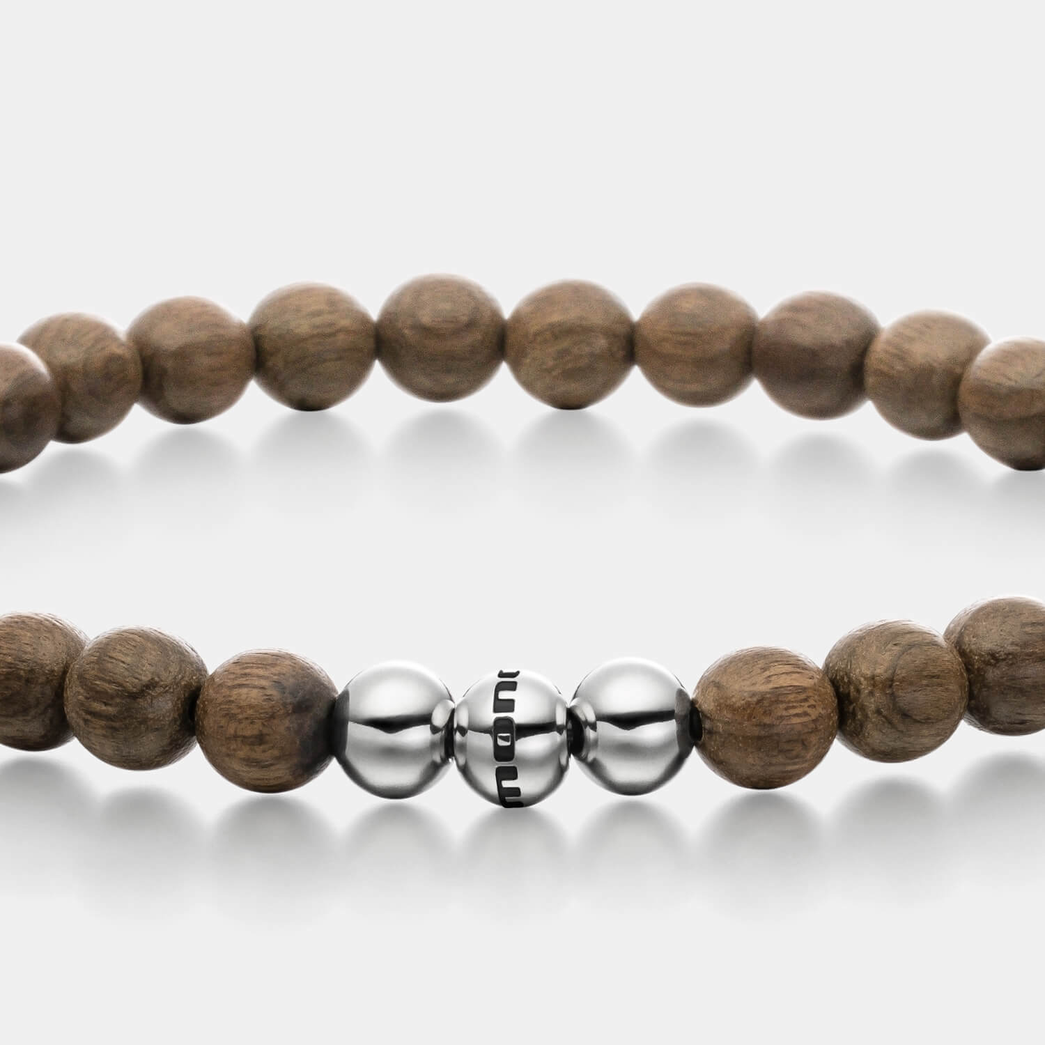 Gesamtansicht eines braunen Perlenarmbandes aus echten Holz-Perlen mit drei antiallergenen Edelstahlperlen.
