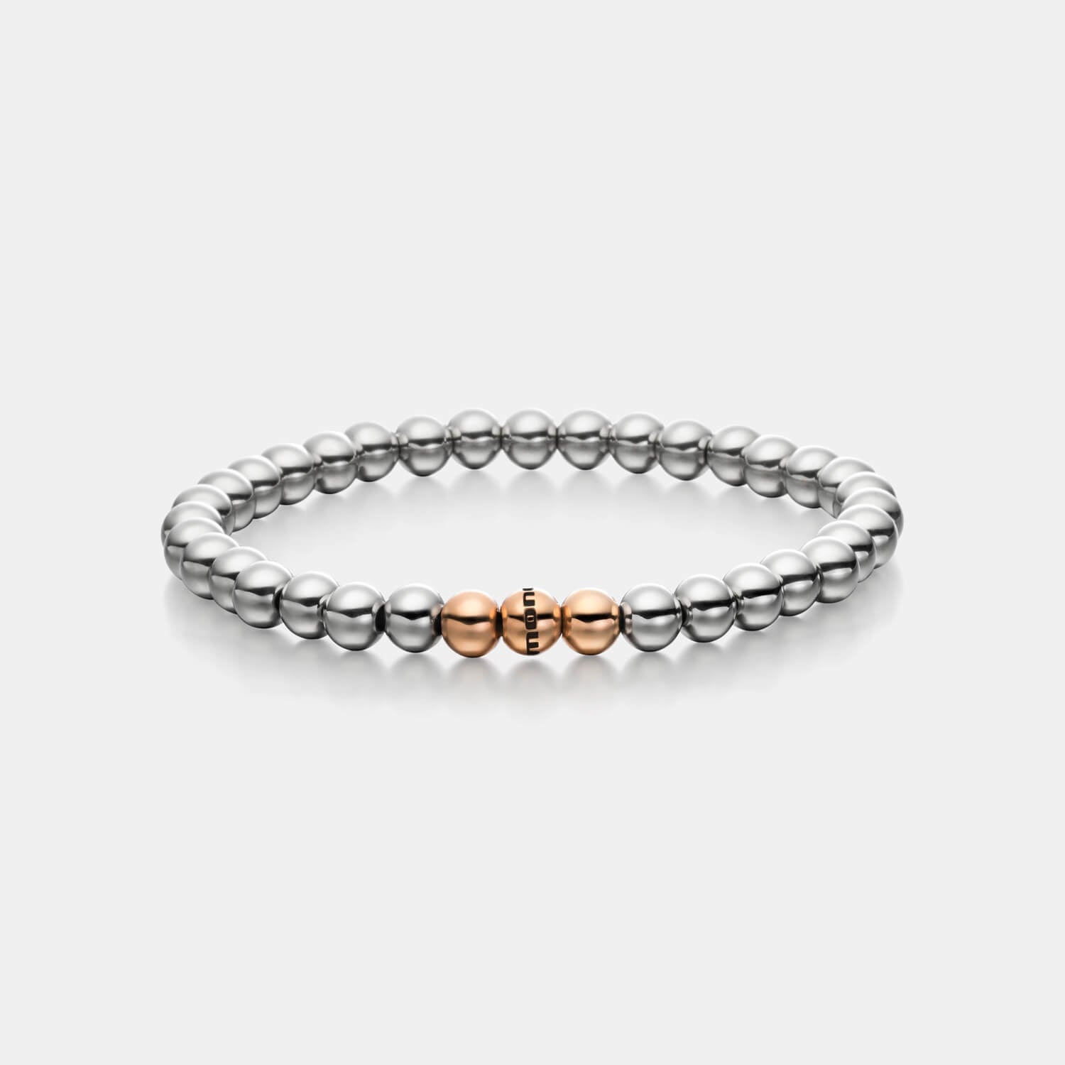 Gesamtansicht eines Perlenarmbandes aus silber-farbenen Edelstahlperlen mit drei roségold-farbenen Perlen.