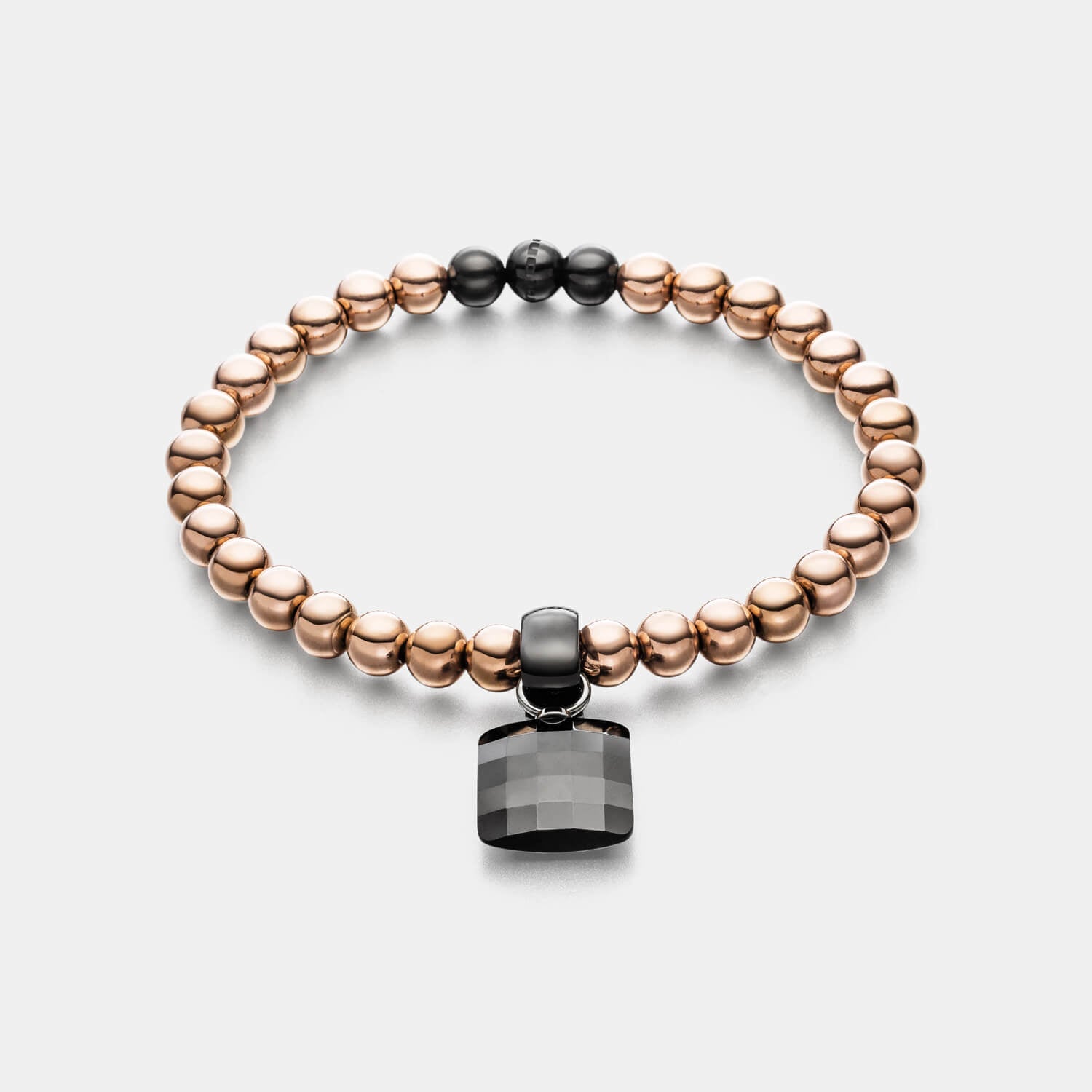 Gesamtansicht eines Perlenarmband-Sets: roségoldfarbenes Perlenarmband mit schwarzem Keramik-Anhänger von MONOMANIA.