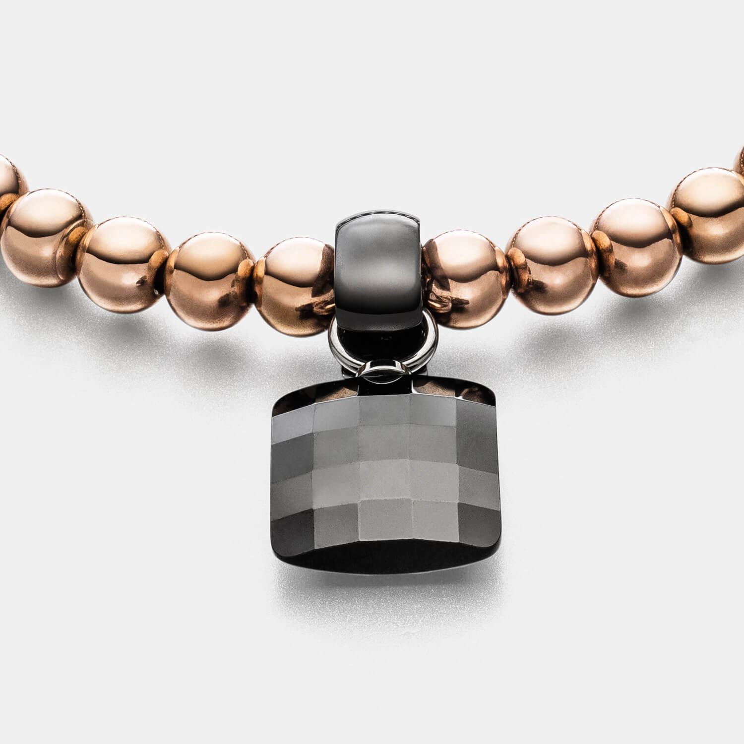 Gesamtansicht eines Perlenarmband-Sets: roségoldfarbenes Perlenarmband mit schwarzem Keramik-Anhänger von MONOMANIA.