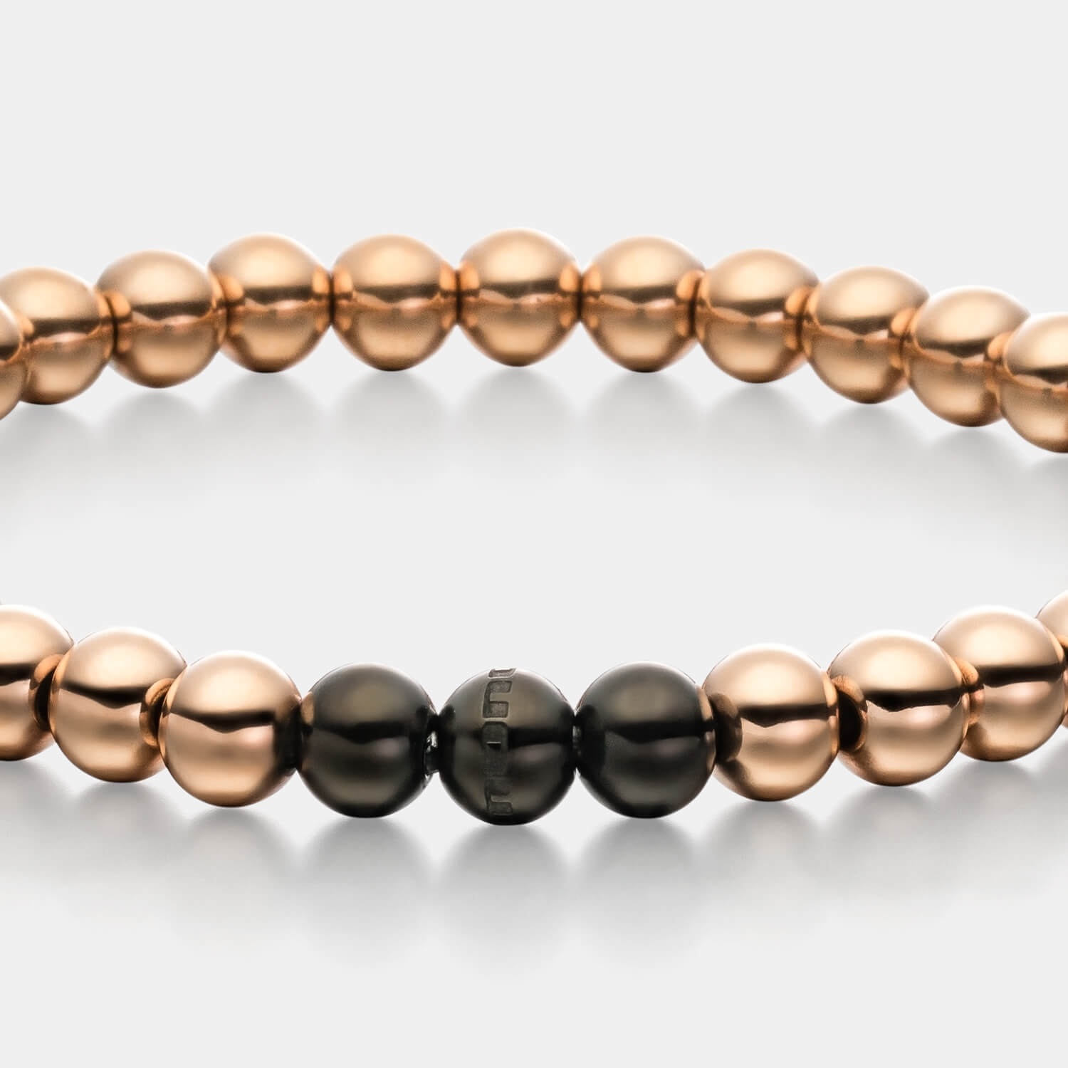 Gesamtansicht eines roségoldfarbenen Perlenarmbandes mit drei schwarz-beschichteten, antiallergenen Edelstahl-Perlen von MONOMANIA.