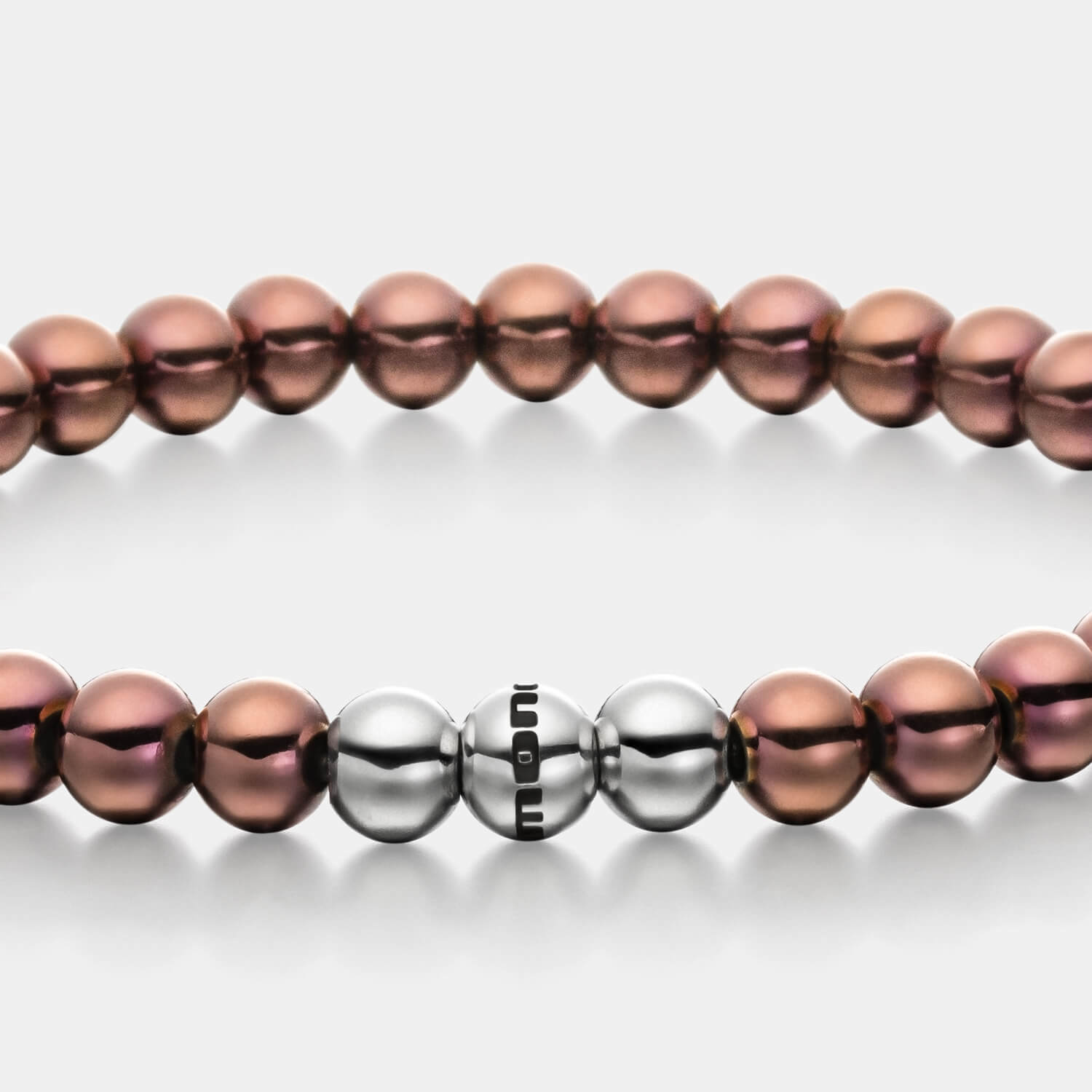 Gesamtansicht eines braunen Perlenarmbandes aus beschichteten Edelstahlperlen mit drei antiallergenen, polierten Edelstahlperlen.