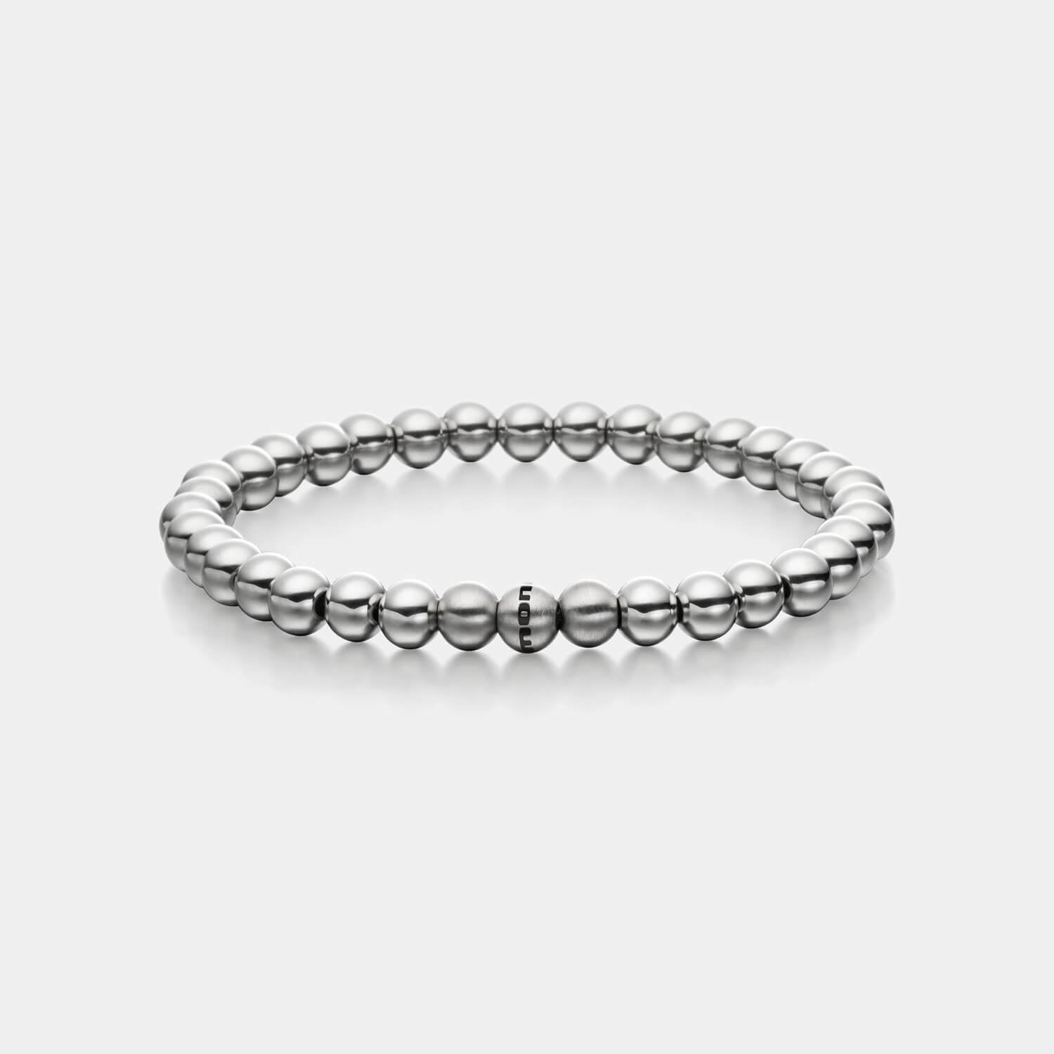Gesamtansicht eines silber-farbenen Perlenarmbandes mit polierten und drei gebürsteten, antiallergenen Edelstahlperlen.