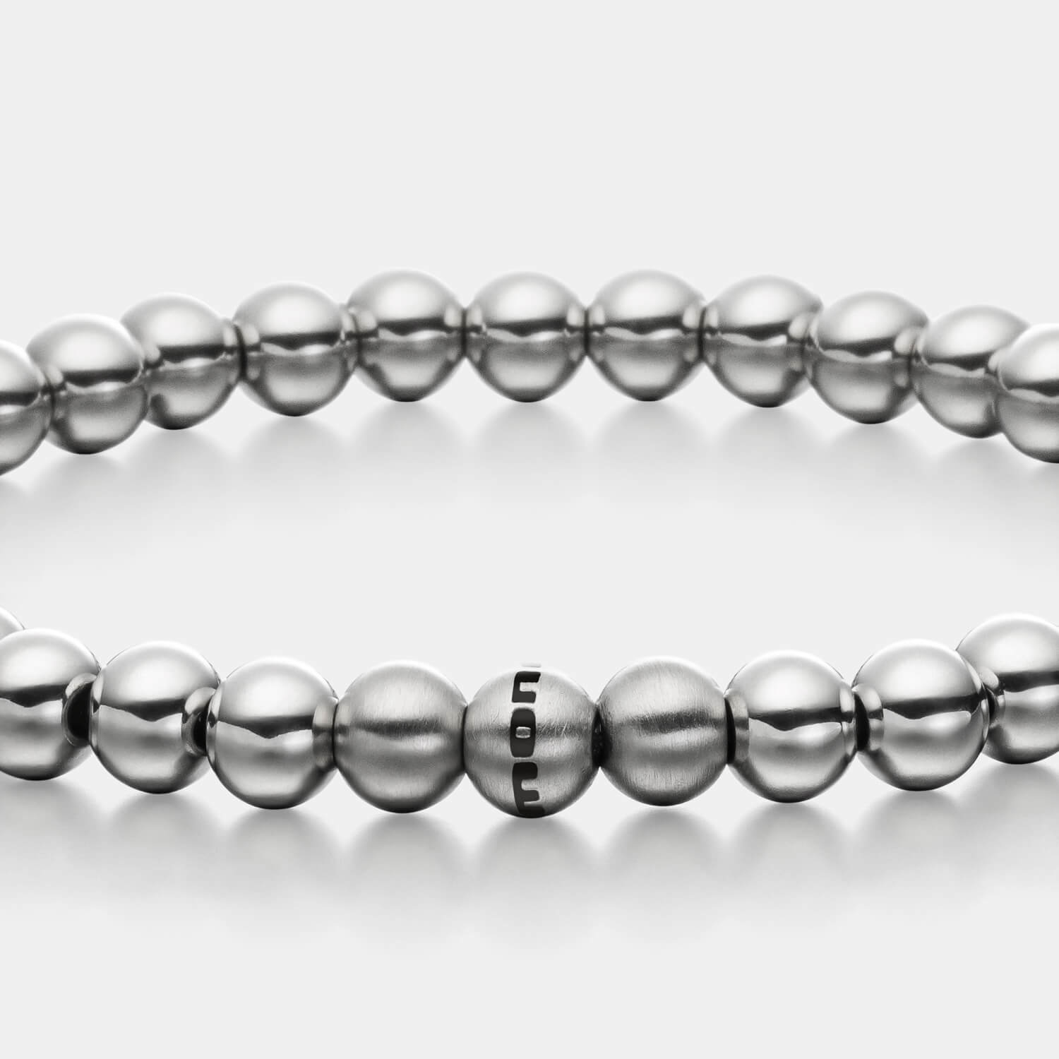 Gesamtansicht eines silber-farbenen Perlenarmbandes mit polierten und drei gebürsteten, antiallergenen Edelstahlperlen.
