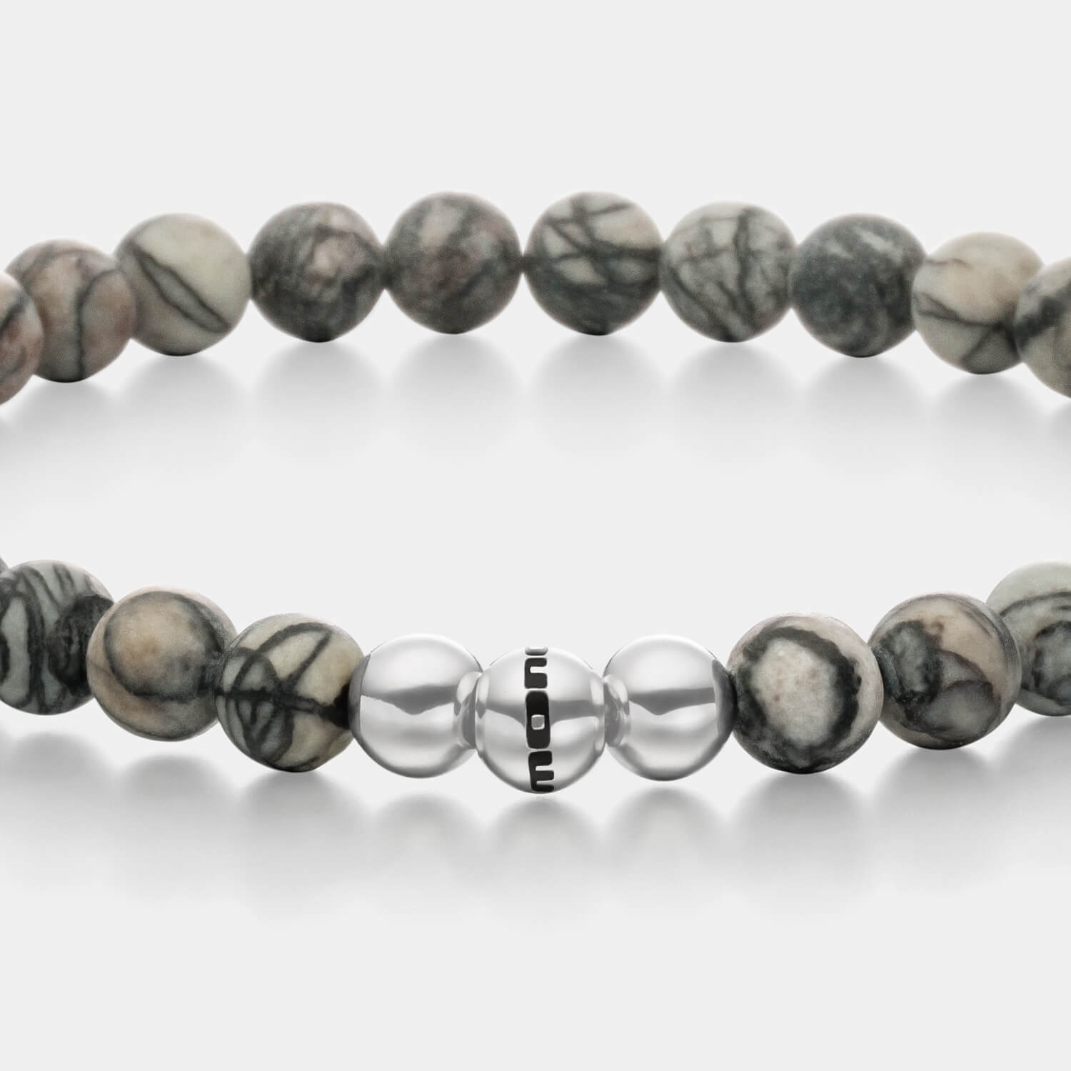 Gesamtansicht eines Perlenarmbandes aus echten grauen Basalt-Perlen mit drei antiallergenen Edelstahlperlen.