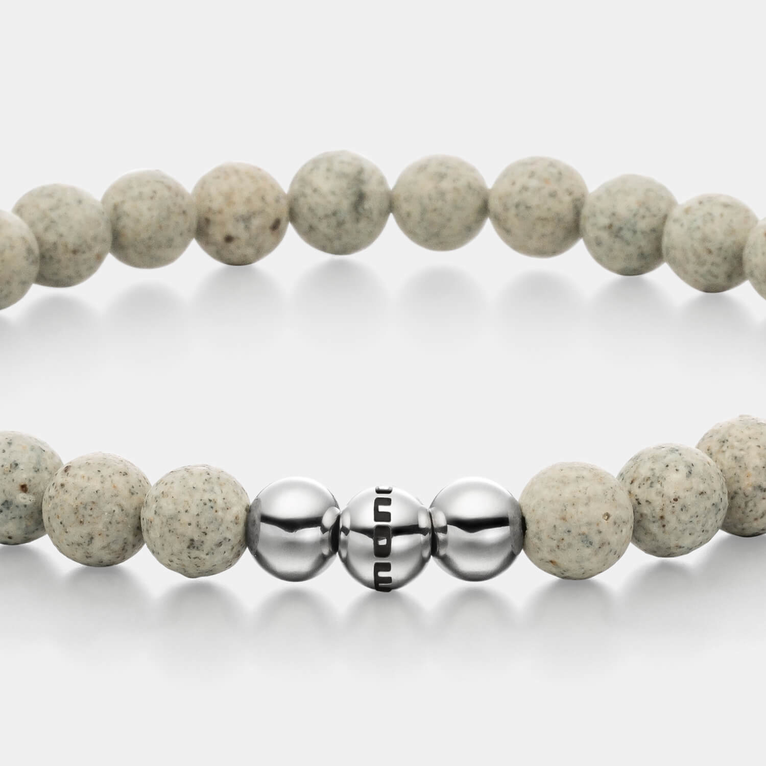 Gesamtansicht eines grauen Perlenarmbandes aus Beton-Perlen kombiniert mit drei polierten, antiallergenen Edelstahlperlen von MONOMANIA.