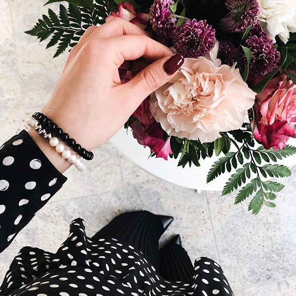 Gesamtansicht eines weißen Perlenarmbandes aus echten Süßwasserperlen mit drei antiallergenen Edelstahlperlen.(109 Zeichen inkl L)