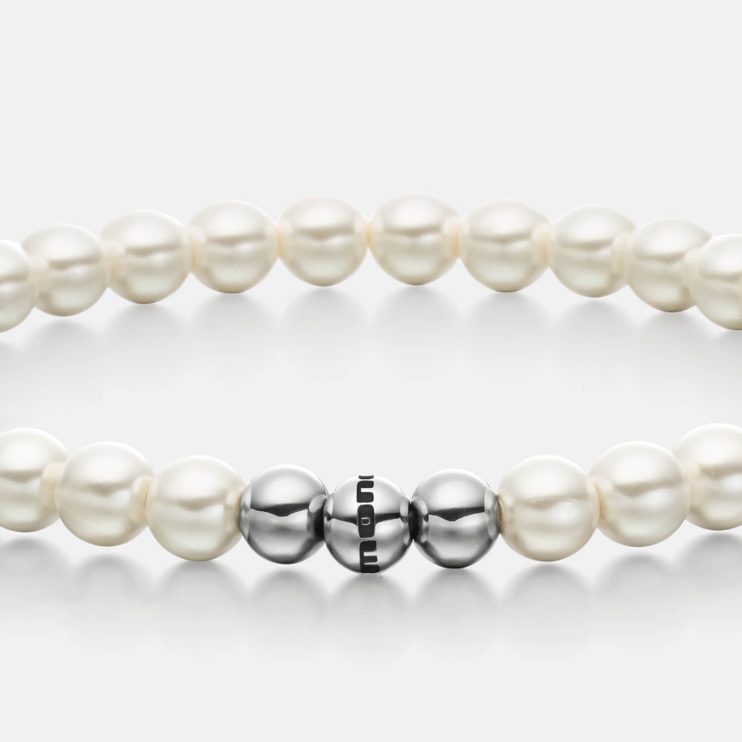 Gesamtansicht eines weißen Perlenarmbandes aus echten Süßwasserperlen mit drei antiallergenen Edelstahlperlen.(109 Zeichen inkl L)