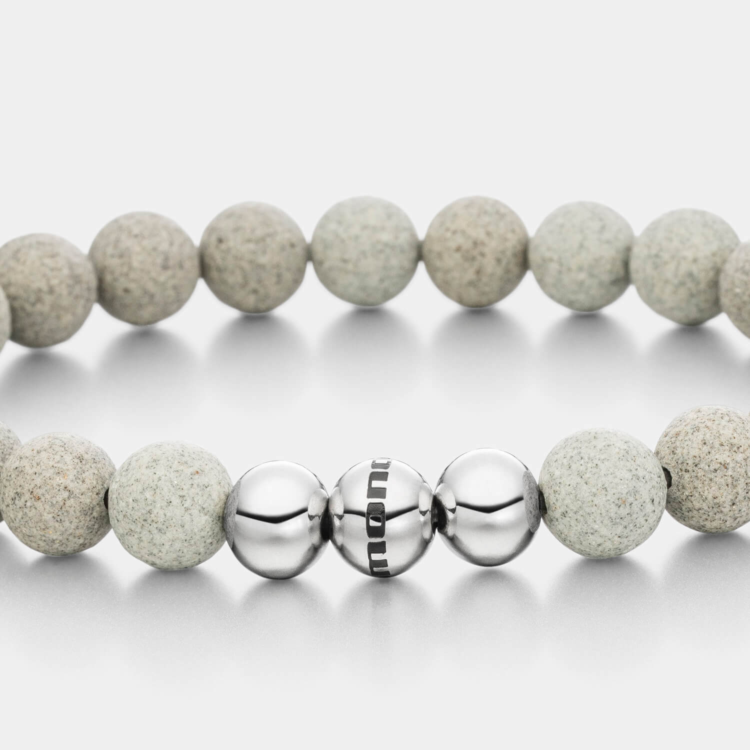 Gesamtansicht eines grauen Perlenarmbandes aus echten Betonperlen mit drei antiallergenen Edelstahlperlen.
