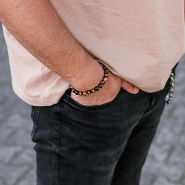 Gesamtansicht eines braunen Perlenarmbandes aus großen, echten Tigerauge-Perlen mit drei antiallergenen Edelstahlperlen.