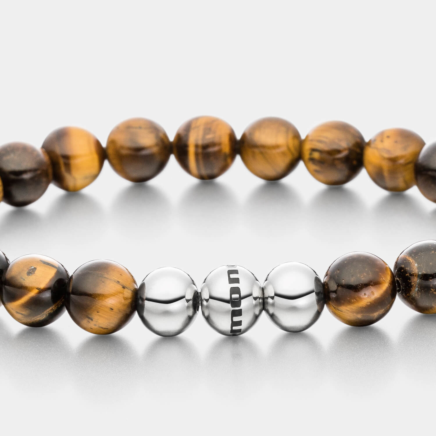 Gesamtansicht eines braunen Perlenarmbandes aus großen, echten Tigerauge-Perlen mit drei antiallergenen Edelstahlperlen.