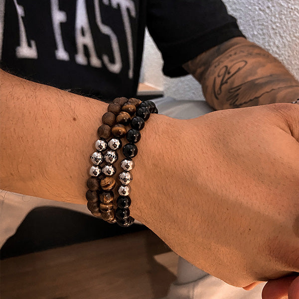 Gesamtansicht eines maskulinen, braunen Perlenarmbandes aus echten Holzperlen aus Nussbaumholz mit drei antiallergenen Edelstahlperlen.