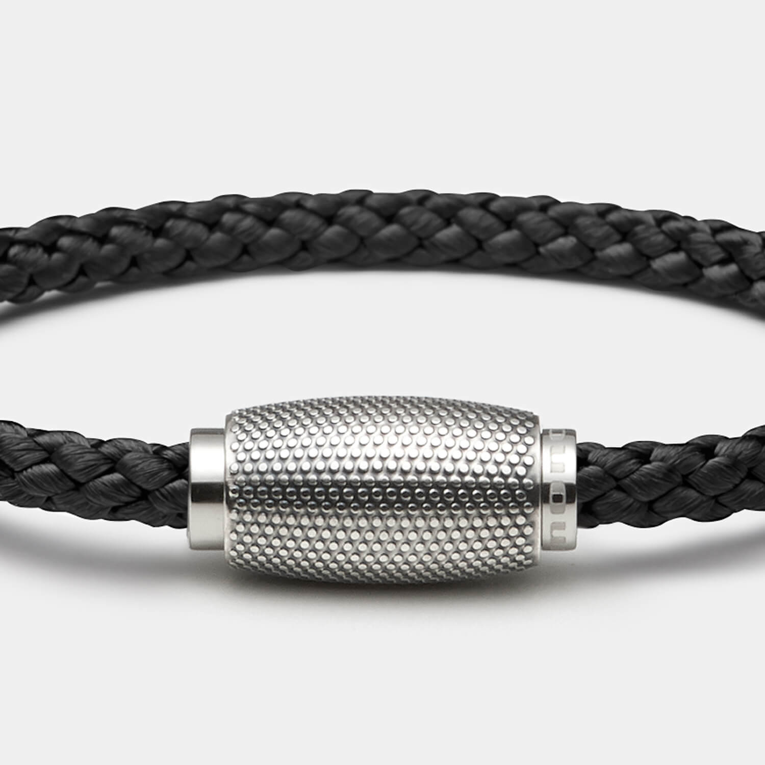 Gesamtansicht eines Armbandes mit schwarzem, geflochtenen Tauwerk und Magnetverschluss mit Punktrelief von MONOMANIA.