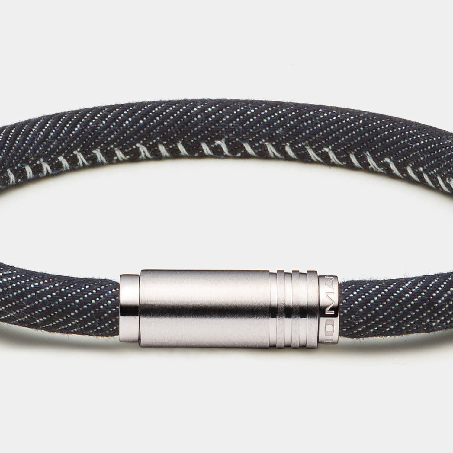 Gesamtansicht der Kombination aus gebürsteter Hülse mit drei Linien-Struktur und einem blauen Jeansband mit Naht von MONOMANIA.