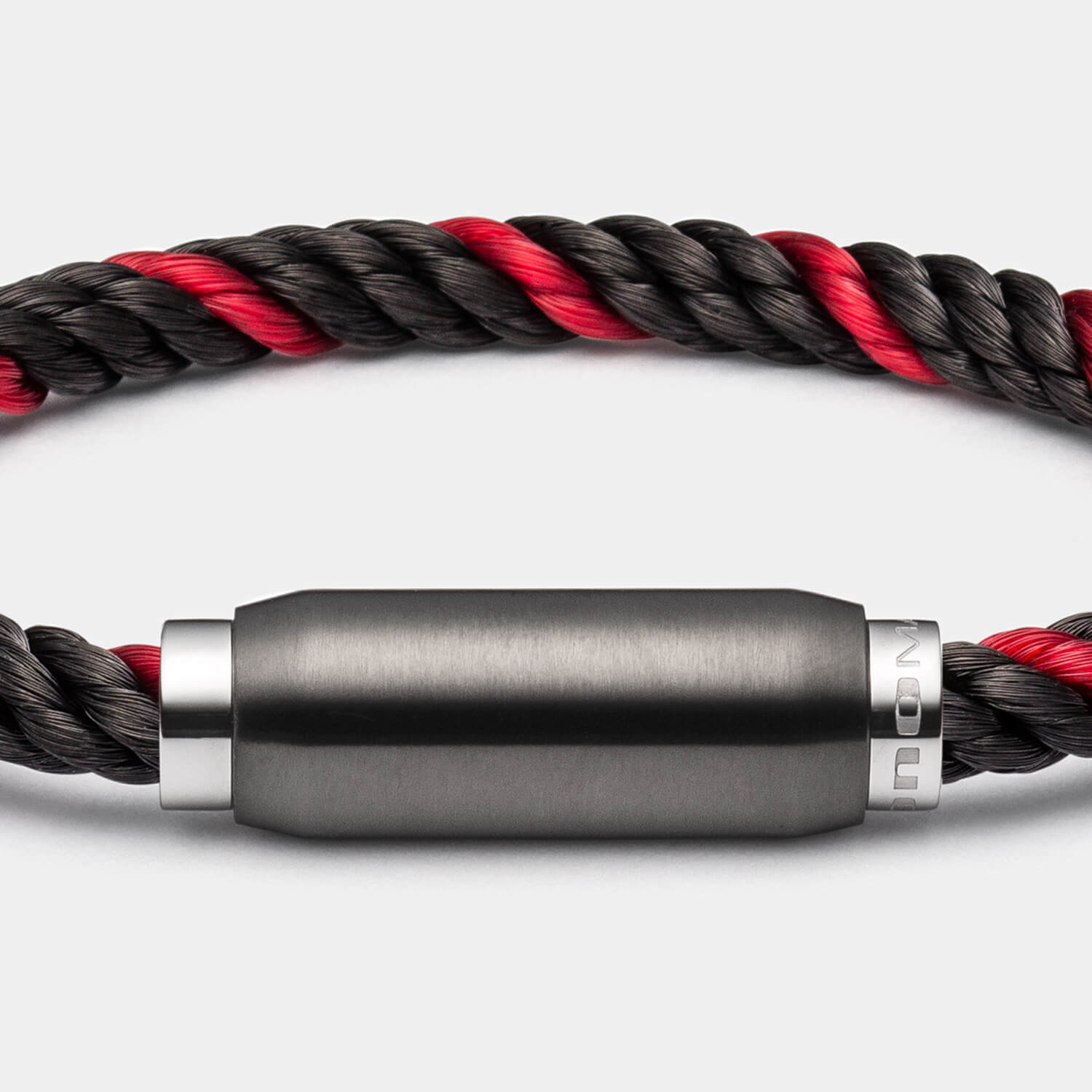 Gesamtansicht eines Armbandes mit einem Band aus schwarz-rotem Materialmix und schwarzem Magnetverschluss von MONOMANIA.