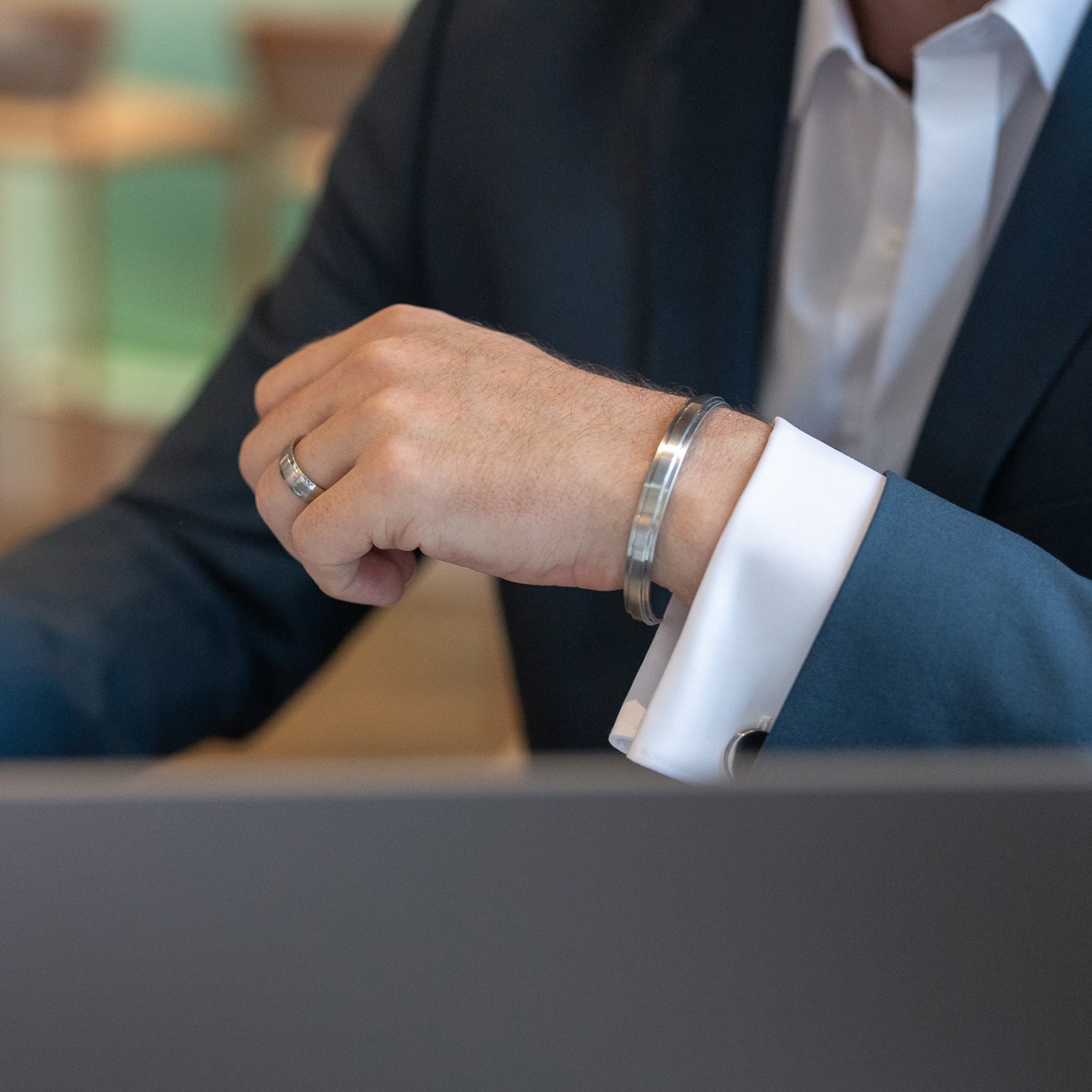 Gesamtansicht eines Armreifs aus teilpoliertem Edelstahl mit erhabener Mittelfläche.