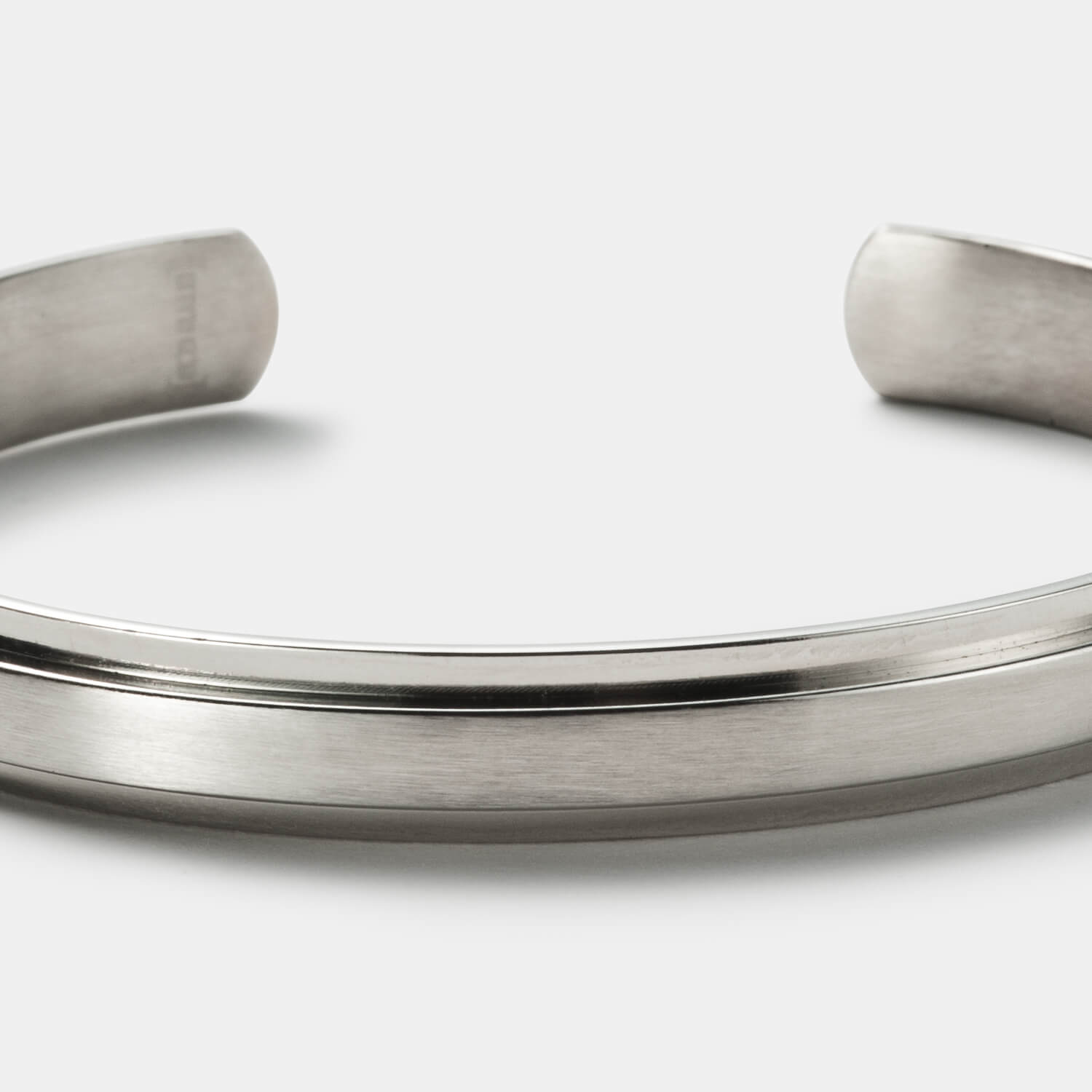 Gesamtansicht eines Armreifs aus teilpoliertem Edelstahl mit erhabener Mittelfläche.