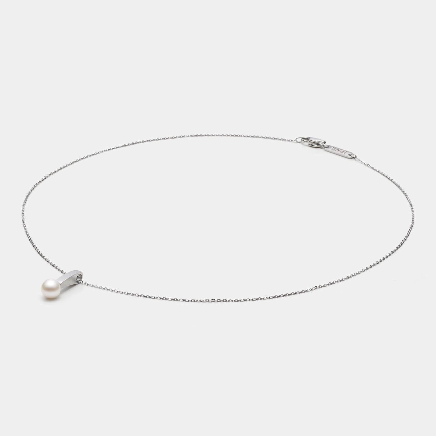 Perspektivische Detailansicht des Pearl´s Kiss Anhängers aus antiallergenem Edelstahl mit Süßwasserperle an einer eleganten Kette mit Karabinerverschluss von MONOMANIA.