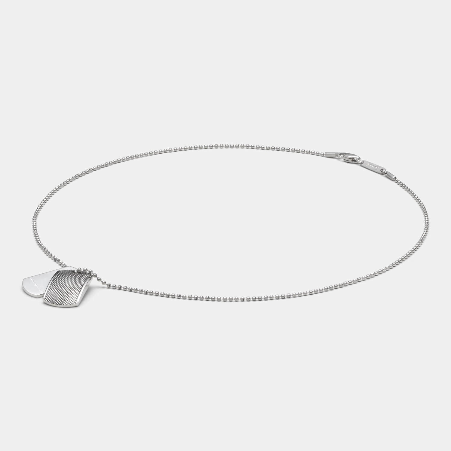 Detailansicht eines silberfarbenen Dog Tag Anhänger-Sets aus antiallergenem Edelstahl mit Punkterelief an einer Kugelkette.