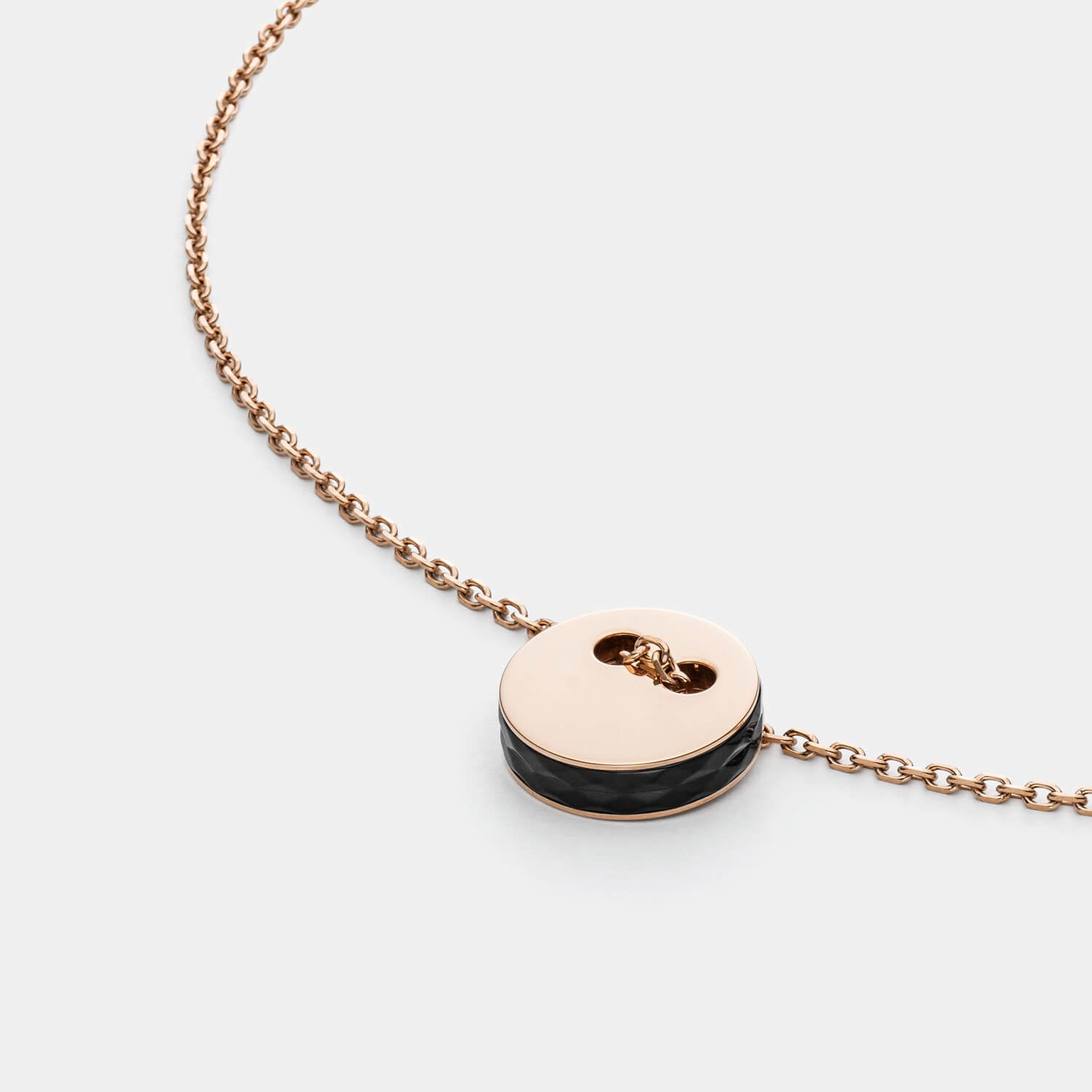 Detailansicht mit Fokus auf den eleganten Anhänger aus roségoldfarbenem, antiallergenen Edelstahl mit schwarzer Seitenfläche inklusive edler Kette von MONOMANIA.