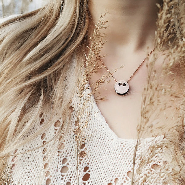 Detailansicht mit Fokus auf den eleganten Anhänger aus roségoldfarbenem, antiallergenen Edelstahl mit schwarzer Seitenfläche inklusive edler Kette von MONOMANIA.