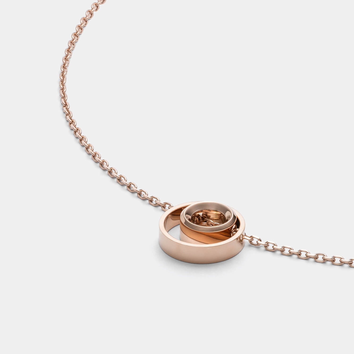 Detailansicht einer feinen, roségold-farbenen Halskette mit Kreisanhängern von MONOMANIA.