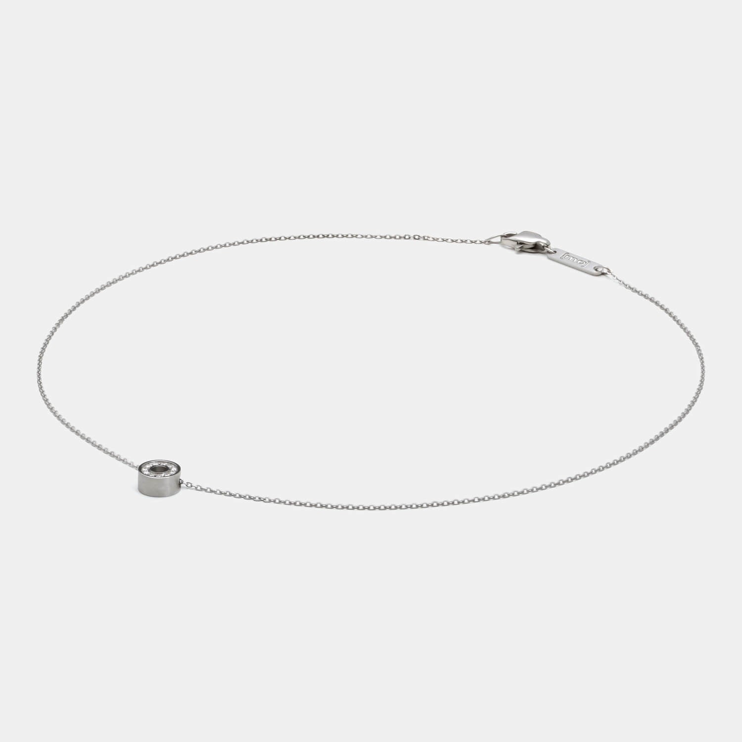 Detailansicht eines runden Edelstahl-Anhängers mit 11 gesetzten, echten Diamanten an einer zarten Kette mit Karabinerverschluss von MONOMANIA.