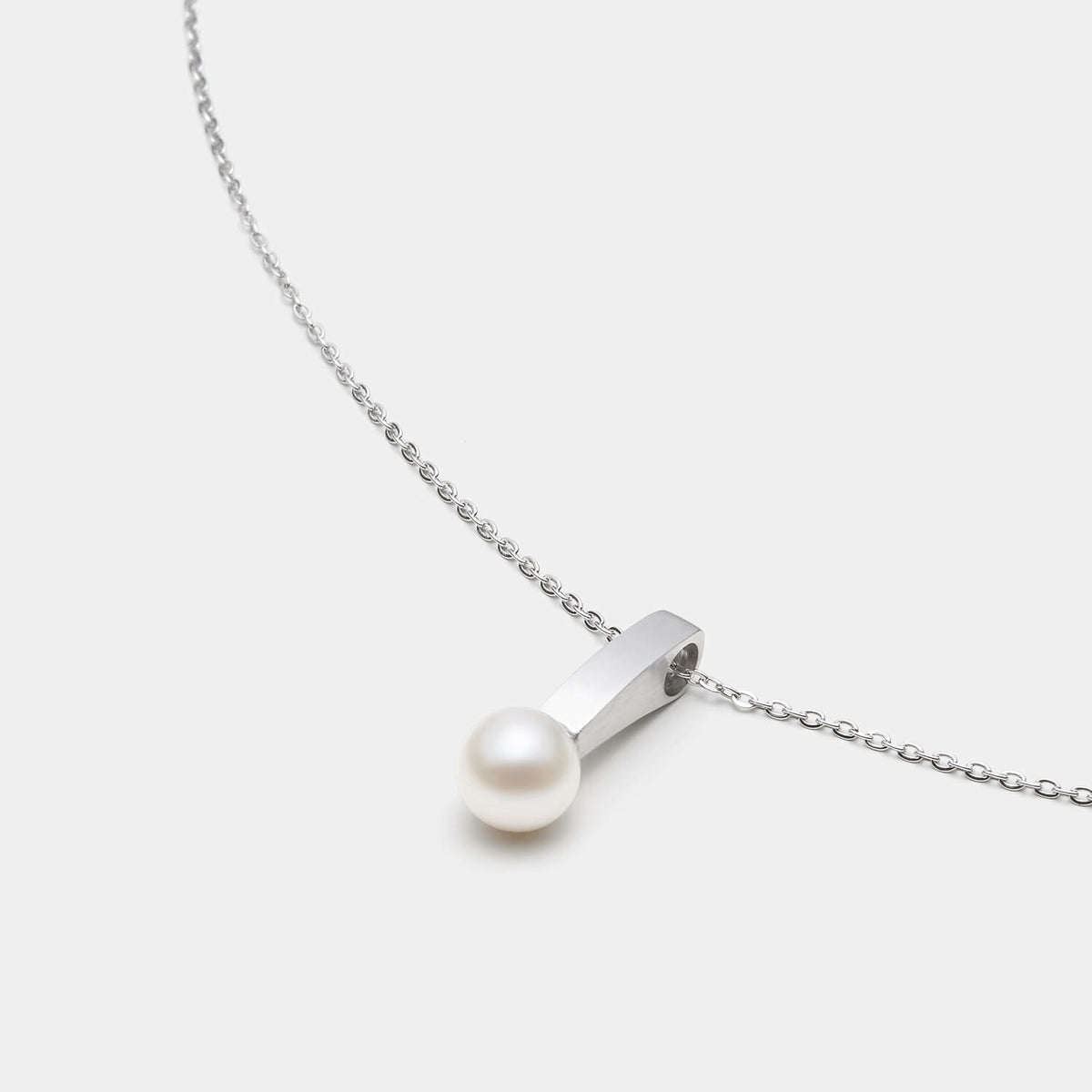 Perspektivische Detailansicht des Pearl´s Kiss Anhängers aus antiallergenem Edelstahl mit Süßwasserperle an einer eleganten Kette mit Karabinerverschluss von MONOMANIA.