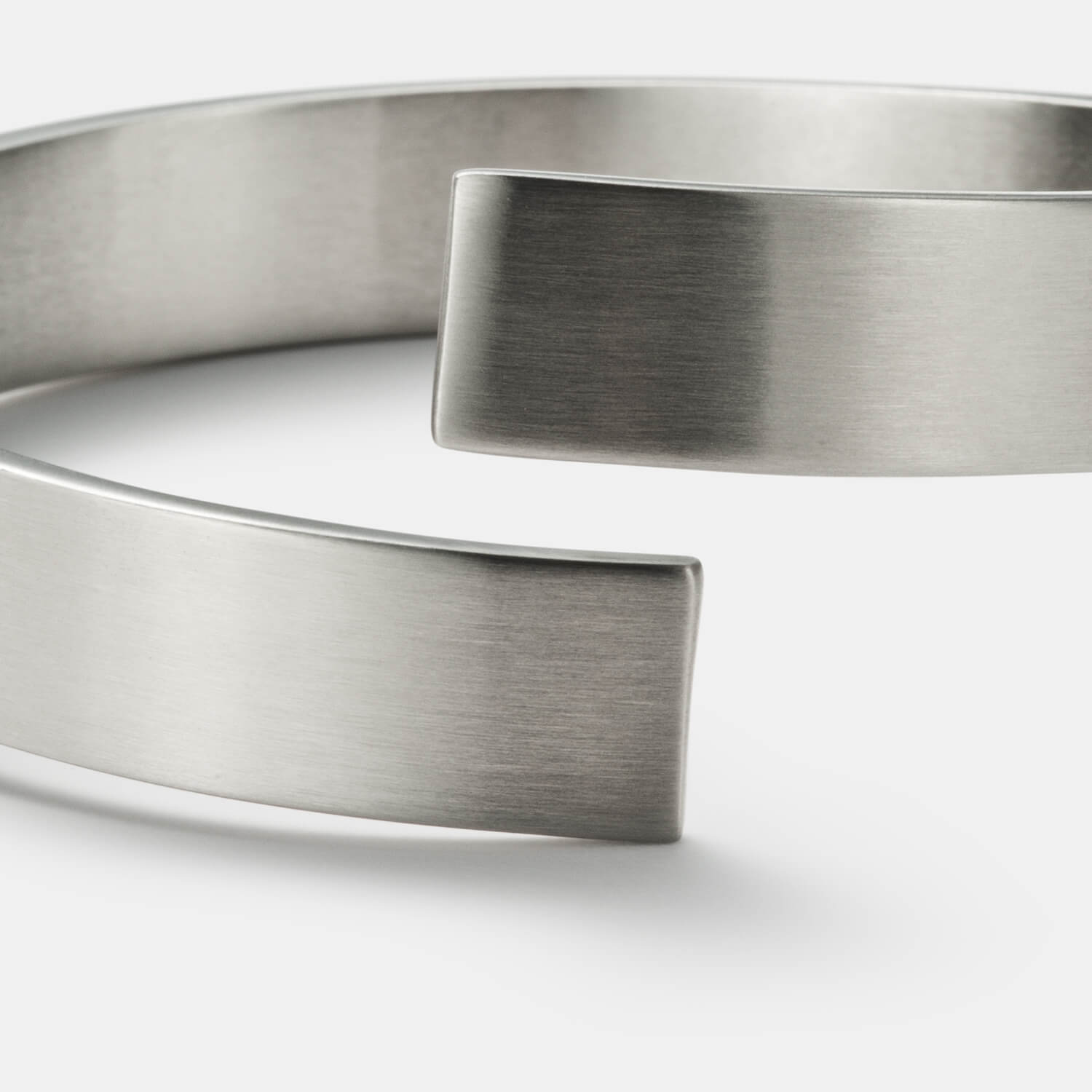 Gesamtansicht eines breiten, verdrehten Armreifs von MONOMANIA.