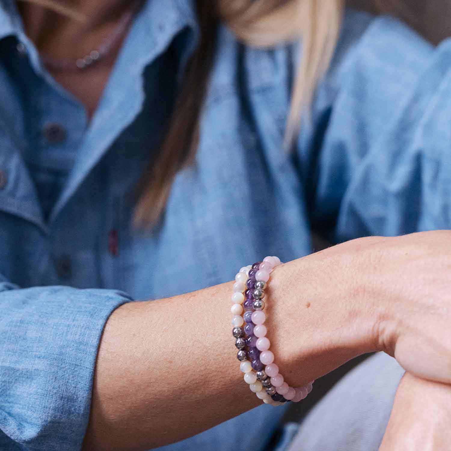 Gesamtansicht eines violetten Perlenarmbandes aus echten Amethystperlen mit drei antiallergenen Edelstahlperlen.