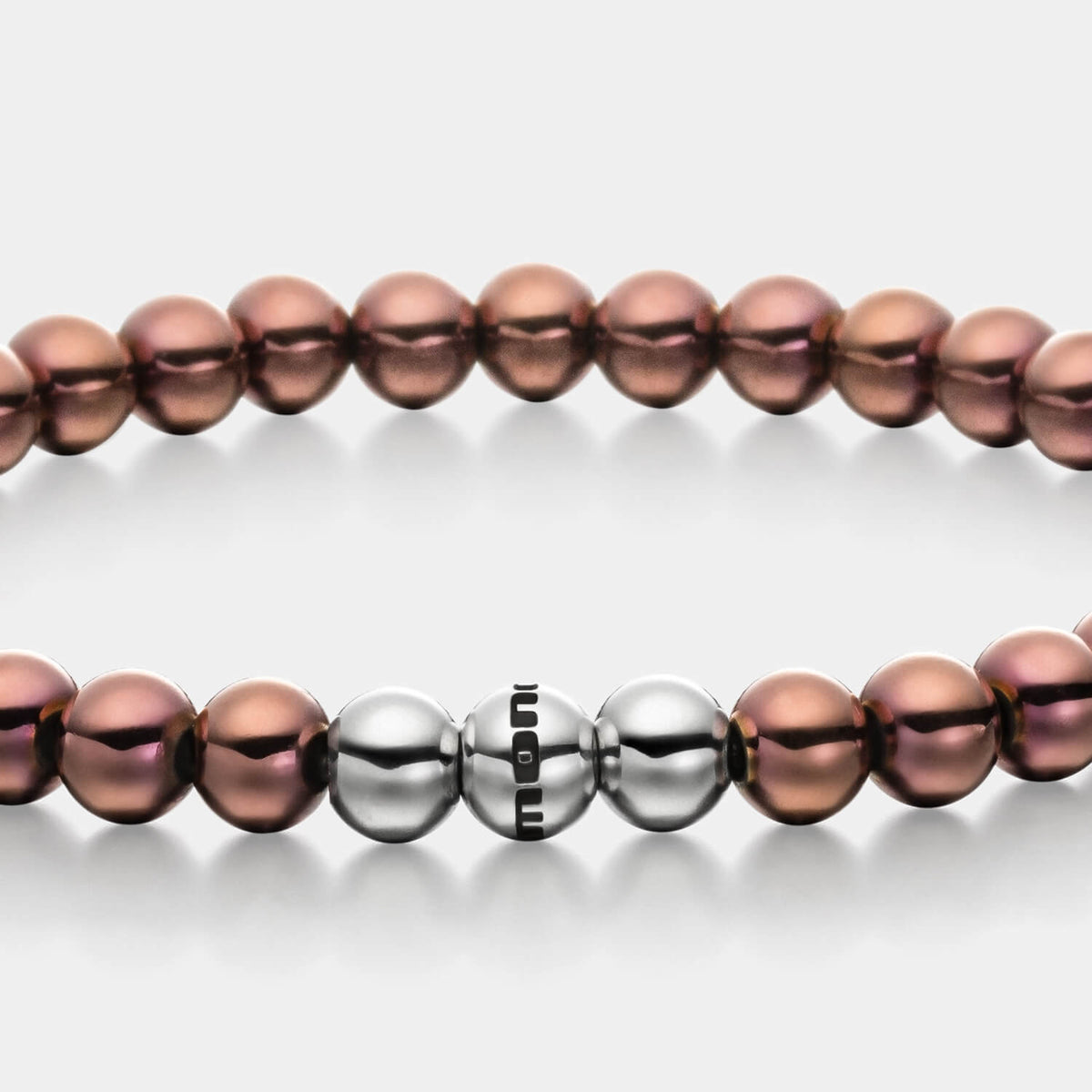 Gesamtansicht eines braunen Perlenarmbandes aus beschichteten Edelstahlperlen mit drei antiallergenen, polierten Edelstahlperlen.