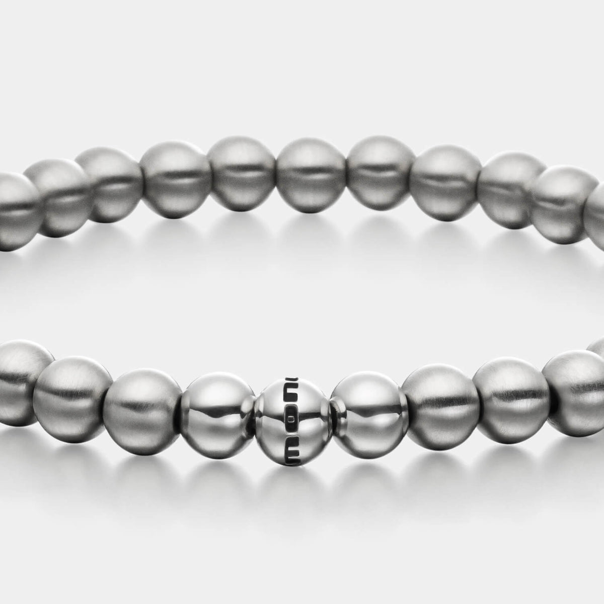 Gesamtansicht eines silberfarbenen, antiallergenen Perlenarmbandes aus echten Edelstahl-Perlen mit drei polierten Edelstahlperlen.
