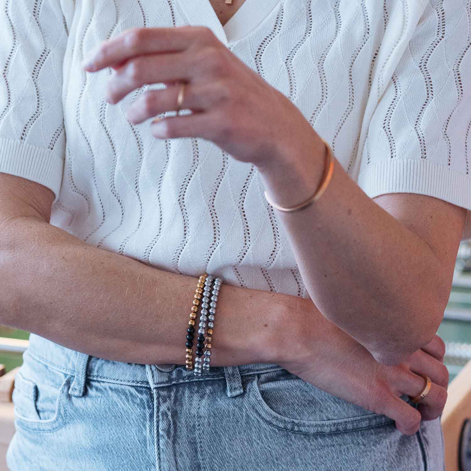 Gesamtansicht eines Perlenarmbandes aus silber-farbenen Edelstahlperlen mit drei roségold-farbenen Perlen.